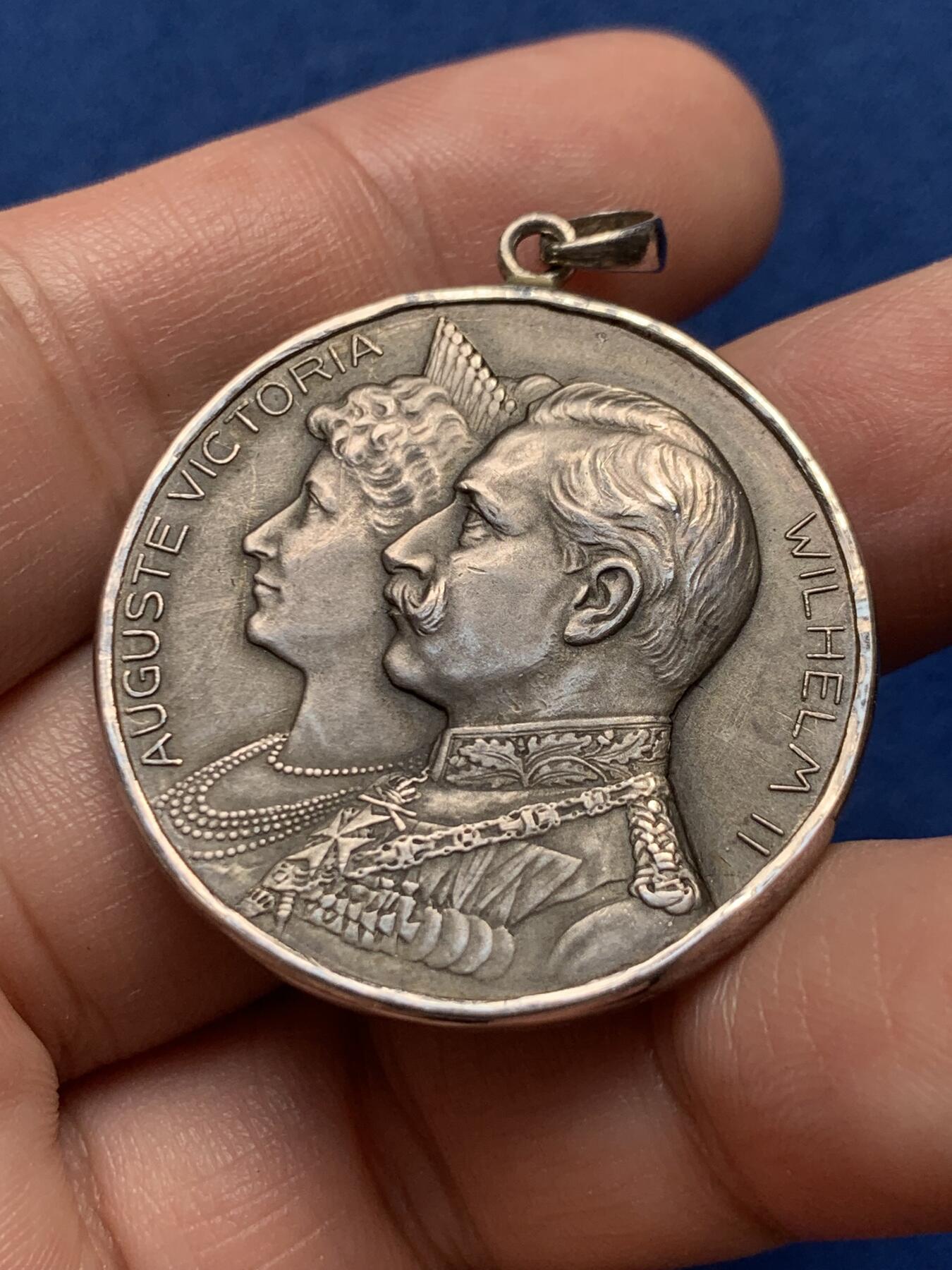 《竞宝斋》第436场 周日，周一2场连拍 （全场包邮） 1906年德国普鲁士威廉二世银婚25周年纪念章吊坠，皇帝威廉二世和皇后奥古斯特维多利亚半身像/两个天使举着皇冠，下方威廉二世花押签名，1881-1906年。整体采用镶嵌工艺接做成了吊坠，内章为950银，外圈吊坠为925银，直径约35毫米，总重约：18.7克。名誉品种，可直接佩戴。