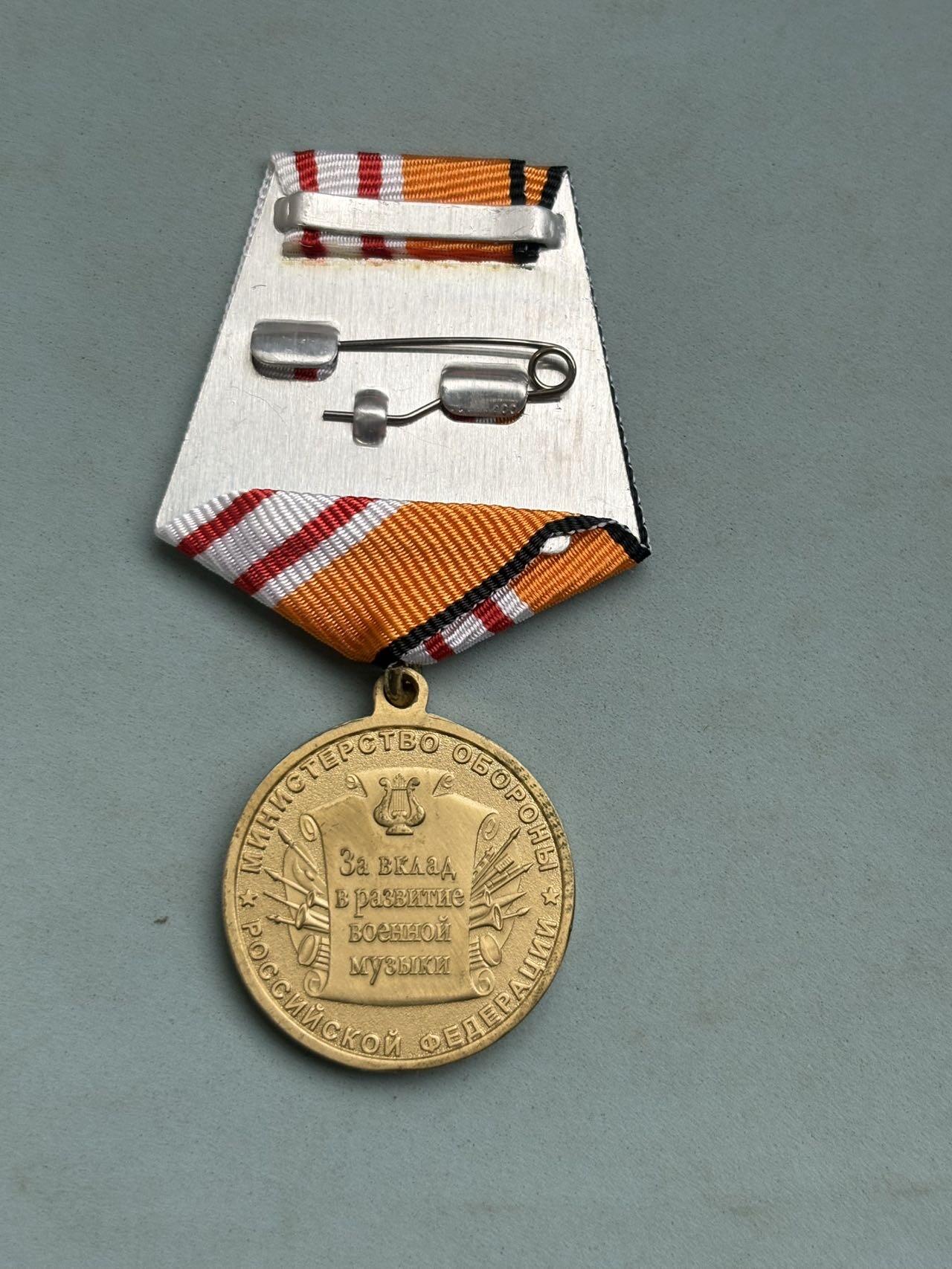 盛世勋华——号角文化勋章邮票专场拍卖第287期 俄罗斯“军事音乐发展贡献奖章”，由俄罗斯国防部设立，授予在军事音乐领域（如军乐团演奏、军事音乐创作、军乐教育等）有突出贡献的人员（包括军人、文职人员等），属于俄军“专业文化贡献类”奖章。