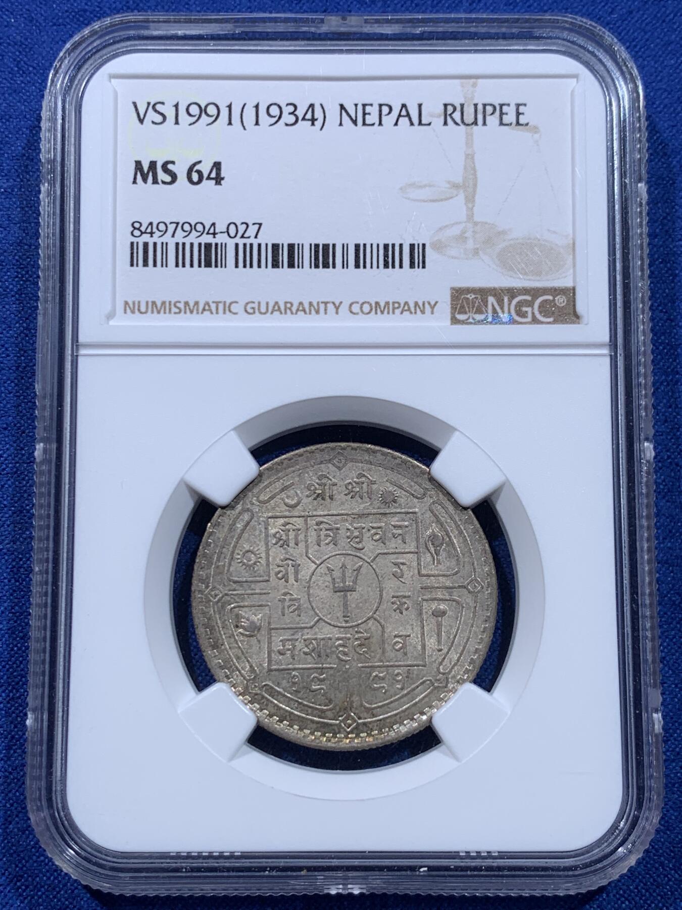《竞宝斋》第437场 周日，周一2场连拍 （全场包邮） NGC MS64 尼泊尔1934年 1卢比银币。从美国老藏家币夹中拆出，有着长久存放产生的烟灰质感包浆，其6点钟方向有着一抹亮眼的金色月牙包浆，给整币画上点睛之笔，让平凡的品种有了非凡的观感。