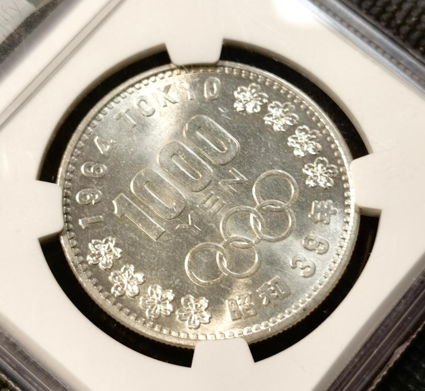 甄臻铺-世界币章拍卖（第39期）送拍享返佣金等优惠多多 NGC-MS63 日本1964年东京奥运1000元银币 车轮转光