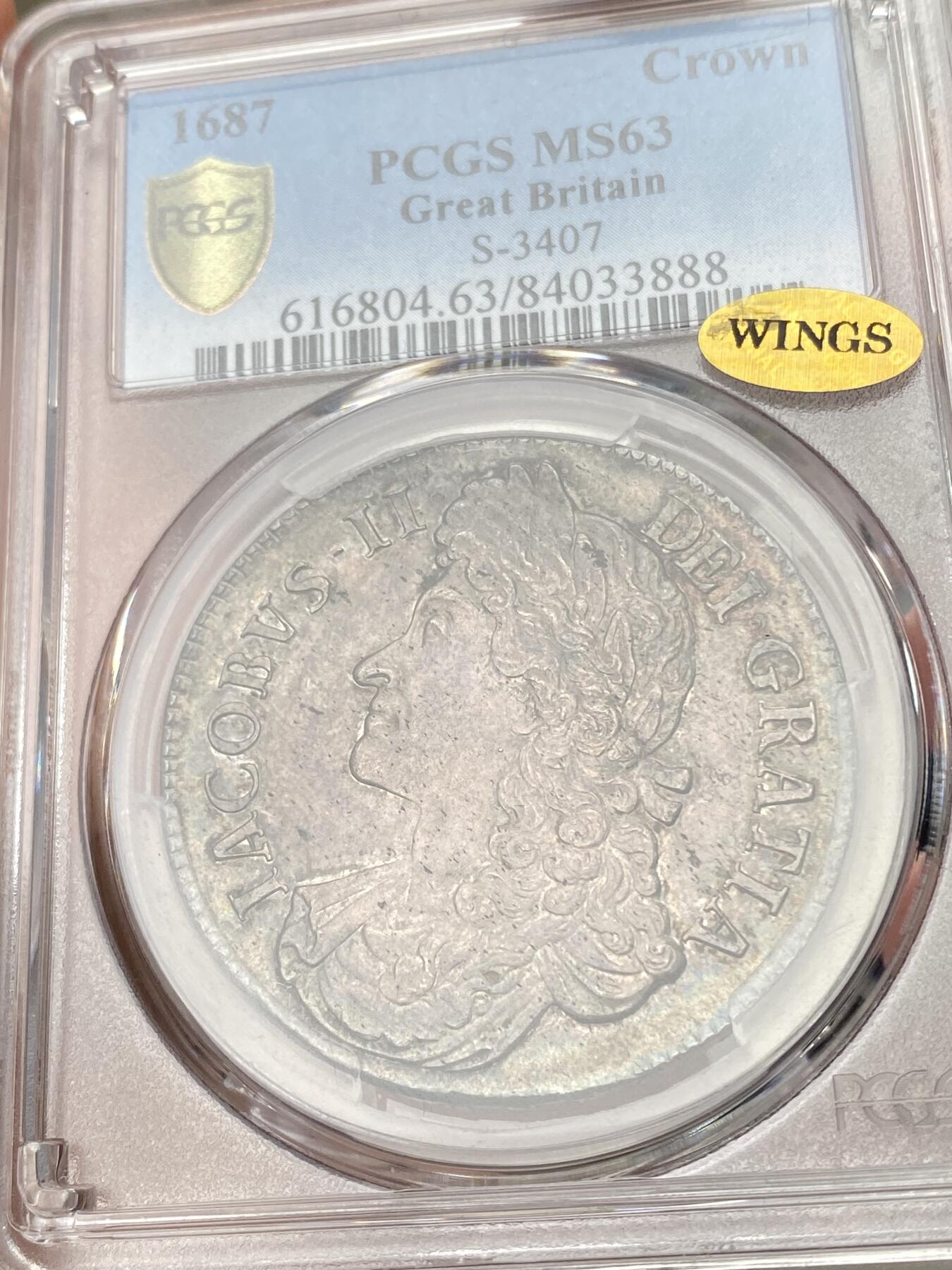 万国钱币拍卖第055期 PCGS MS63 1687年英国詹姆斯二世克朗 斯图亚特王朝复辟后第二位国王 柔美的英式乌云五彩倒影包浆 机铸纹清晰可见 底板转光依旧 WING金标认证的顶级状态 对于一枚17世纪的英国克朗来说已是可遇不可求的典藏品质
