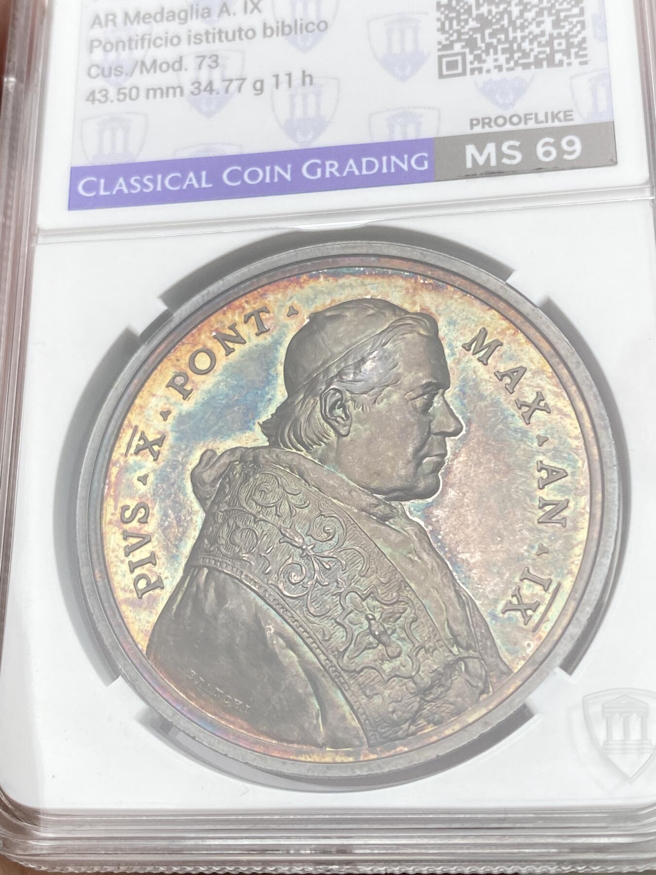 万国钱币拍卖第055期 CCG MS69 1912年梵蒂冈教皇国圣经研究所学院成立纪念大银章 罗马造币厂铸 底板均匀孔雀蓝幻彩与浮雕的喷砂交辉相应极美 意大利本土评级 分数仅供参考