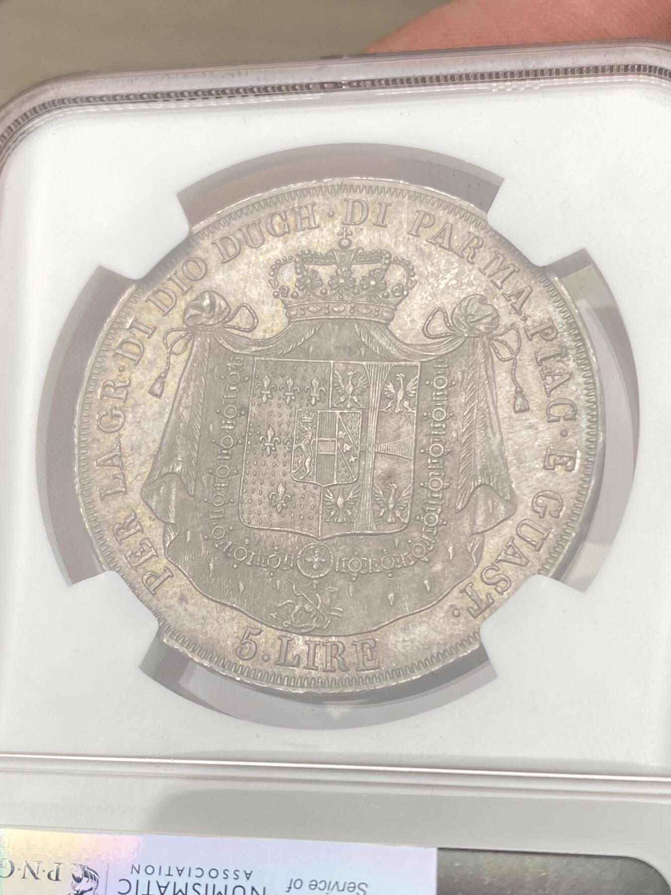 万国钱币拍卖第055期 NGC MS63 1815年意大利帕尔马5里拉银币 正面肖像为拿皇夫人，著名的帕尔马女大公玛丽亚·露易丝，背面是繁复华丽的帕尔马公国纹章，双面均匀欧陆五彩，国际市场广受欢迎的品种，好品也是越来越难见到，此等典藏级品质不可错过。