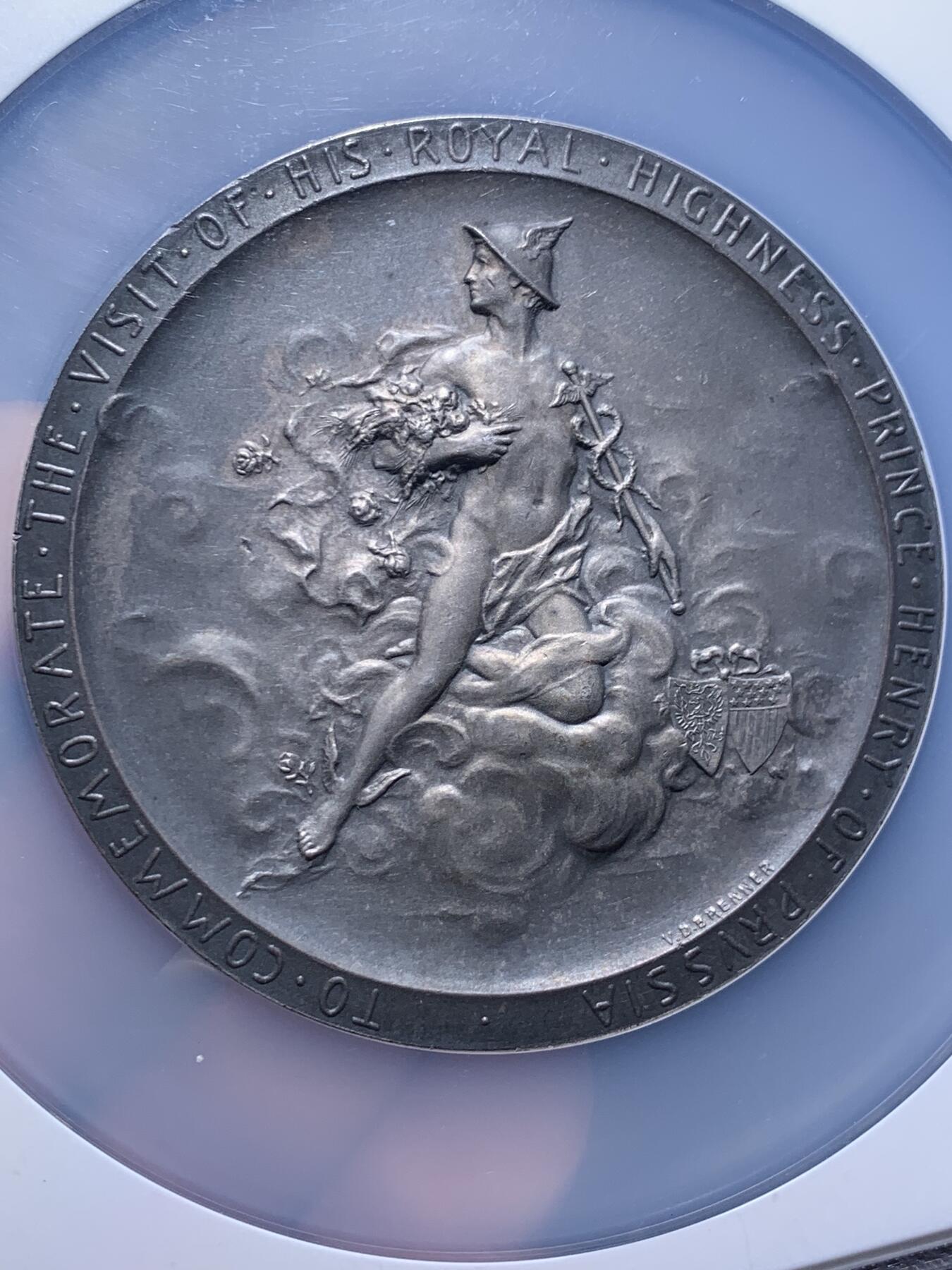 《竞宝斋》第438场 周日，周一，周二 3场连拍 （全场包邮） NGC MS64 美国1902年纪念德国普鲁士王子访问纪念大银章。尺寸69.7MM，拿在手里沉甸甸。正面为中老年身穿戎装的普鲁士王子，背面为代表商业繁荣的墨丘利身处云层中看向西方。在背面的右下角还有代表美国的盾徽和普鲁士的鹰徽连在一起。不管是王子人像面还是墨丘利面都雕刻的极其繁复。发行量301枚，matte工艺，入盒首见。