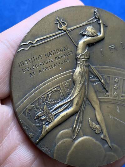《竞宝斋》第438场 周日，周一，周二 3场连拍 （全场包邮） 名家DAMMANN作 1927年法国无线电报协会纪念大铜章 原铸  法国新艺术运动时期勋章艺术集珍 章牌编号：DAMMANN-1927-TSF   意象隐喻：彩虹女神伊里斯在希腊神话中司掌通信，其足踝双翼象征无远弗届的无线电波，科技符号：背面六边形天线网格暗合当时最先进的六角形蜂窝状信号塔设计，宇宙观表达：黄道带与星空的组合，暗示无线电技术突破时空界限的哲学意义。134.5克，67.5mm，丰饶角