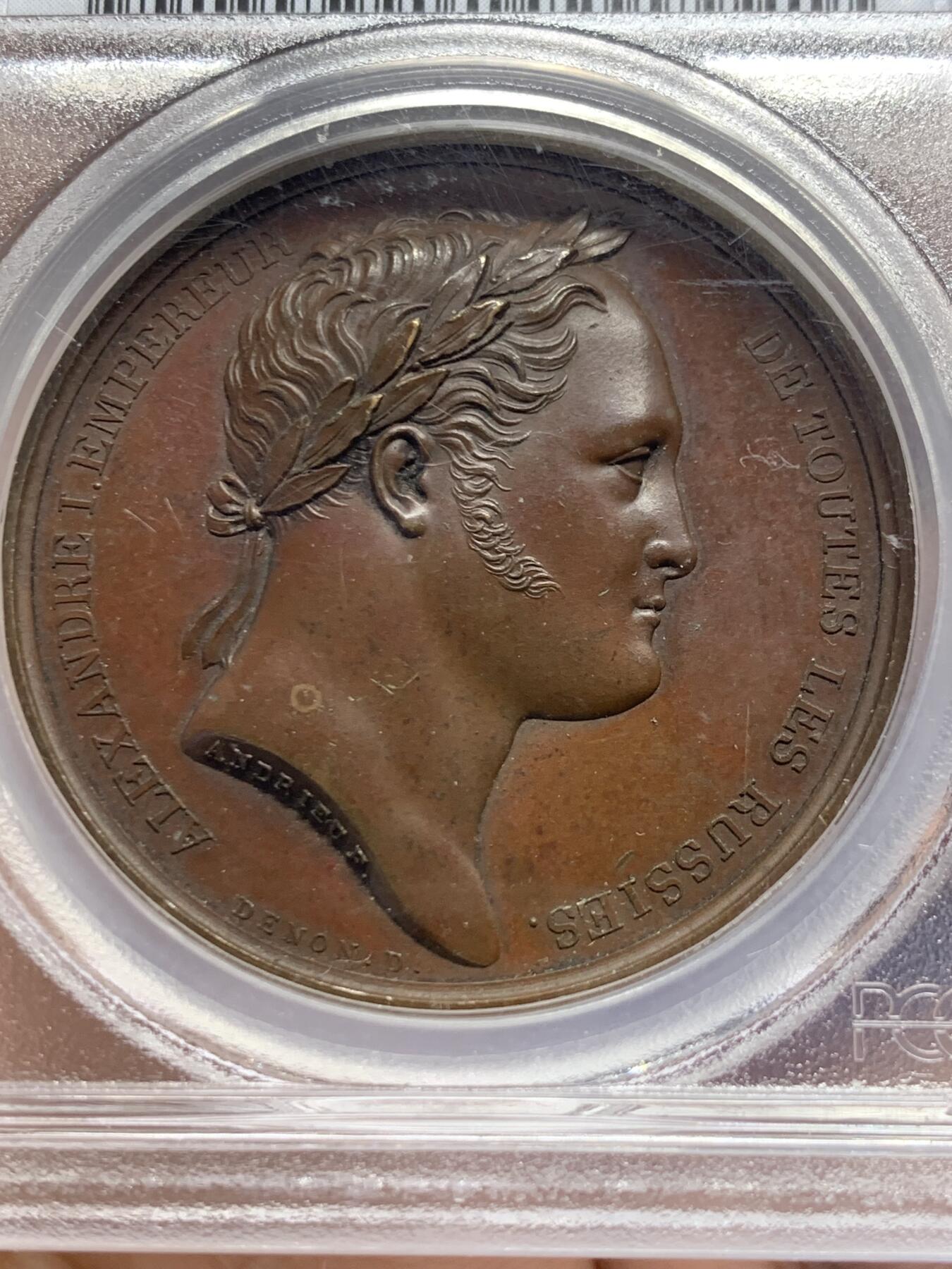 《竞宝斋》第438场 周日，周一，周二 3场连拍 （全场包邮） PCGS SP64 亚军分 法国1814年沙皇亚历山大一世访问巴黎铜章 正面沙皇月桂冠高浮雕，完全拿章典型风格头像，背面天使坐于树荫下书写历史，纪念沙皇占领期访巴黎造币厂，第六次反法同盟胜利，法兰西第一帝国覆灭，拿皇退位流放，巴黎由俄军掌管。作为胜利者的沙皇骑着白马率大军通过凯旋门，不知他是否满脑一年前拿皇攻占莫斯科场景，与其说“访问巴黎”，不如说彰显复仇拿皇的耀武扬威。