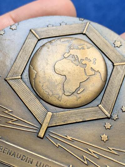 《竞宝斋》第438场 周日，周一，周二 3场连拍 （全场包邮） 名家DAMMANN作 1927年法国无线电报协会纪念大铜章 原铸  法国新艺术运动时期勋章艺术集珍 章牌编号：DAMMANN-1927-TSF   意象隐喻：彩虹女神伊里斯在希腊神话中司掌通信，其足踝双翼象征无远弗届的无线电波，科技符号：背面六边形天线网格暗合当时最先进的六角形蜂窝状信号塔设计，宇宙观表达：黄道带与星空的组合，暗示无线电技术突破时空界限的哲学意义。134.5克，67.5mm，丰饶角