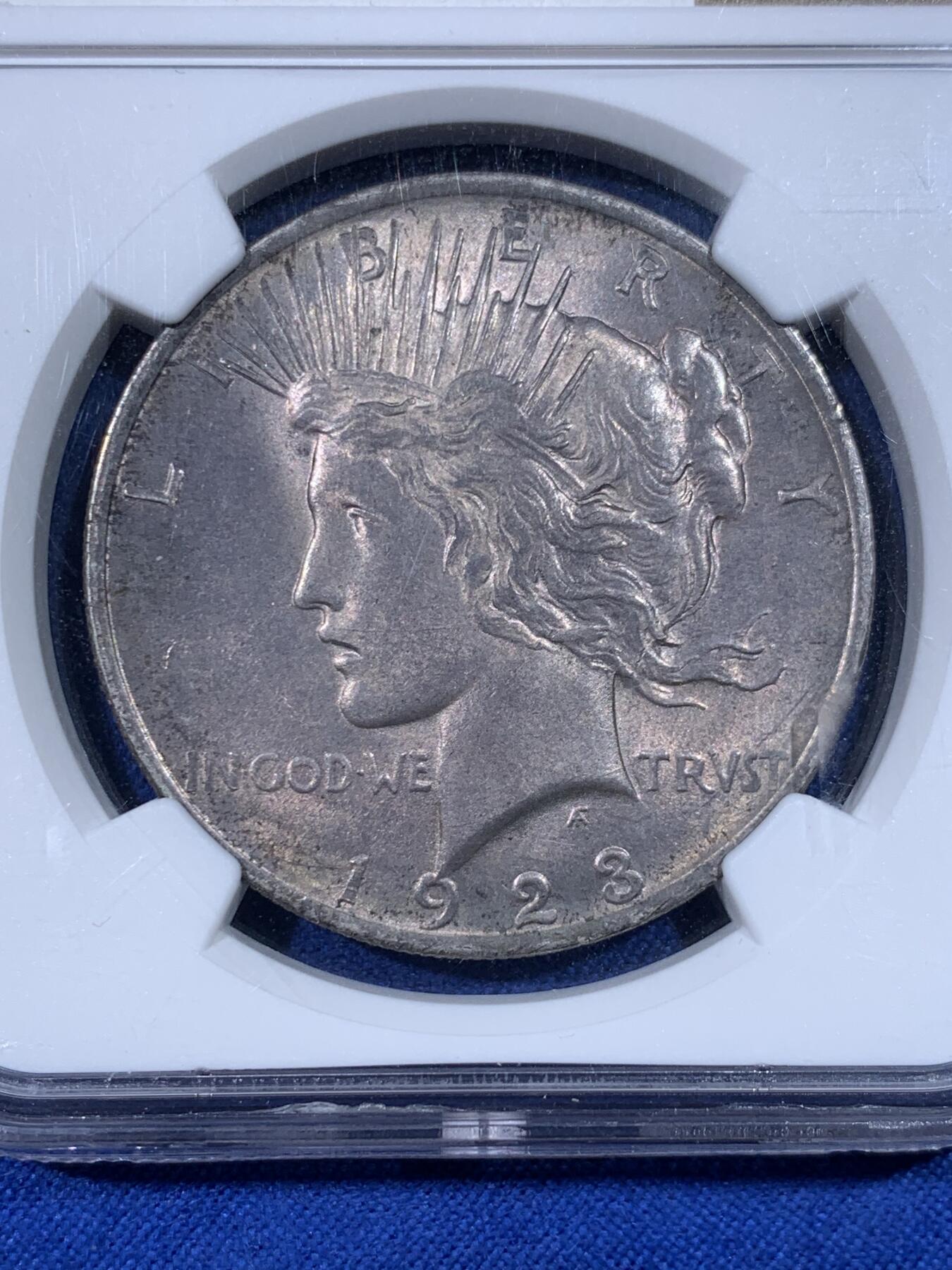 《竞宝斋》第438场 周日，周一，周二 3场连拍 （全场包邮） NGC MS62 美国1923年和平银币 两面均匀的灰彩，和平银币铸造过程中添加了抑制氧化的材料，所以和平带彩的非常少 非常难得，因此也比白币贵许多