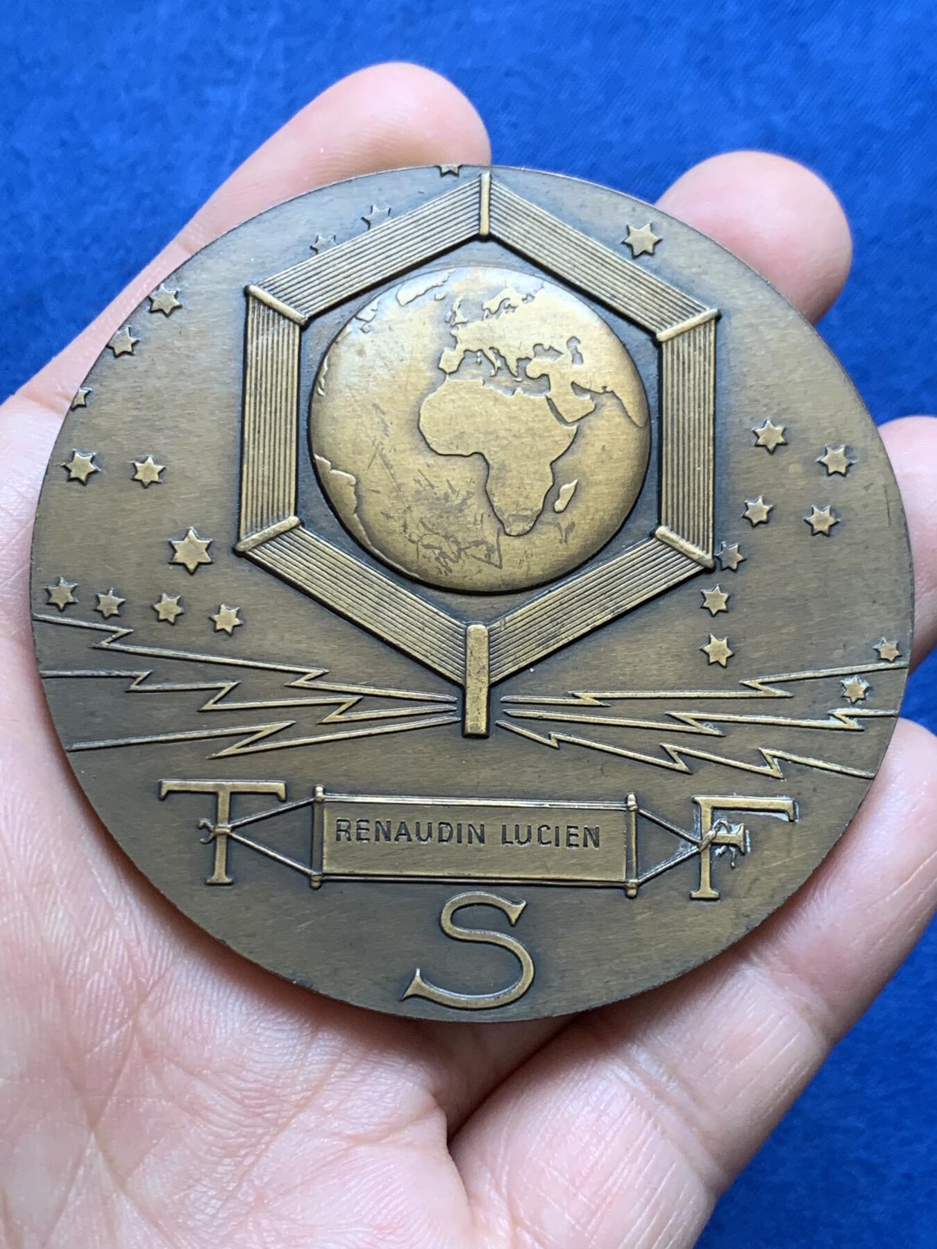 《竞宝斋》第438场 周日，周一，周二 3场连拍 （全场包邮） 名家DAMMANN作 1927年法国无线电报协会纪念大铜章 原铸  法国新艺术运动时期勋章艺术集珍 章牌编号：DAMMANN-1927-TSF   意象隐喻：彩虹女神伊里斯在希腊神话中司掌通信，其足踝双翼象征无远弗届的无线电波，科技符号：背面六边形天线网格暗合当时最先进的六角形蜂窝状信号塔设计，宇宙观表达：黄道带与星空的组合，暗示无线电技术突破时空界限的哲学意义。134.5克，67.5mm，丰饶角