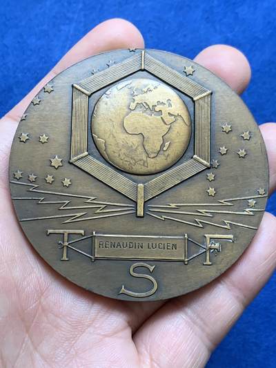 《竞宝斋》第438场 周日，周一，周二 3场连拍 （全场包邮） 名家DAMMANN作 1927年法国无线电报协会纪念大铜章 原铸  法国新艺术运动时期勋章艺术集珍 章牌编号：DAMMANN-1927-TSF   意象隐喻：彩虹女神伊里斯在希腊神话中司掌通信，其足踝双翼象征无远弗届的无线电波，科技符号：背面六边形天线网格暗合当时最先进的六角形蜂窝状信号塔设计，宇宙观表达：黄道带与星空的组合，暗示无线电技术突破时空界限的哲学意义。134.5克，67.5mm，丰饶角