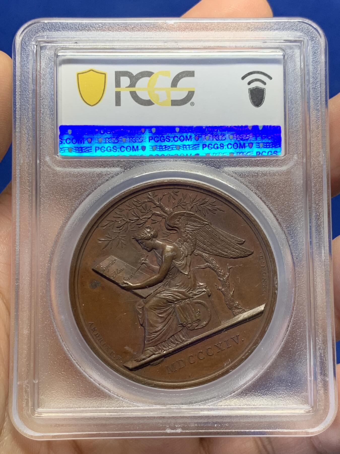 《竞宝斋》第438场 周日，周一，周二 3场连拍 （全场包邮） PCGS SP64 亚军分 法国1814年沙皇亚历山大一世访问巴黎铜章 正面沙皇月桂冠高浮雕，完全拿章典型风格头像，背面天使坐于树荫下书写历史，纪念沙皇占领期访巴黎造币厂，第六次反法同盟胜利，法兰西第一帝国覆灭，拿皇退位流放，巴黎由俄军掌管。作为胜利者的沙皇骑着白马率大军通过凯旋门，不知他是否满脑一年前拿皇攻占莫斯科场景，与其说“访问巴黎”，不如说彰显复仇拿皇的耀武扬威。
