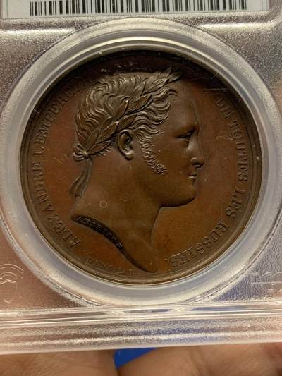 《竞宝斋》第438场 周日，周一，周二 3场连拍 （全场包邮） PCGS SP64 亚军分 法国1814年沙皇亚历山大一世访问巴黎铜章 正面沙皇月桂冠高浮雕，完全拿章典型风格头像，背面天使坐于树荫下书写历史，纪念沙皇占领期访巴黎造币厂，第六次反法同盟胜利，法兰西第一帝国覆灭，拿皇退位流放，巴黎由俄军掌管。作为胜利者的沙皇骑着白马率大军通过凯旋门，不知他是否满脑一年前拿皇攻占莫斯科场景，与其说“访问巴黎”，不如说彰显复仇拿皇的耀武扬威。