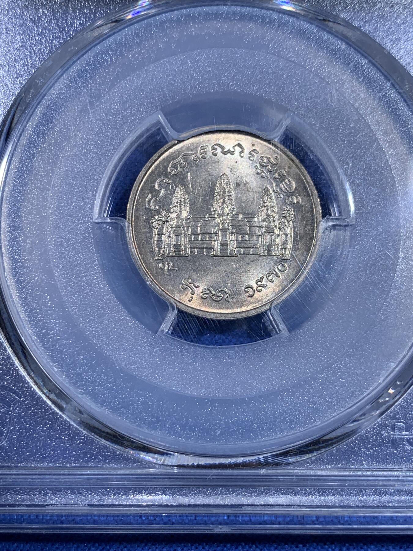 《竞宝斋》第439场 周日，周一，周二 3场连拍 （全场包邮） PCGS MS65 柬埔寨红色高棉政权发行的纪念币。英国皇家造币厂代工。1971年并没有发行。直到1980年代后市面上才陆续见到。数量稀少，盒子左上角有内裂纹。