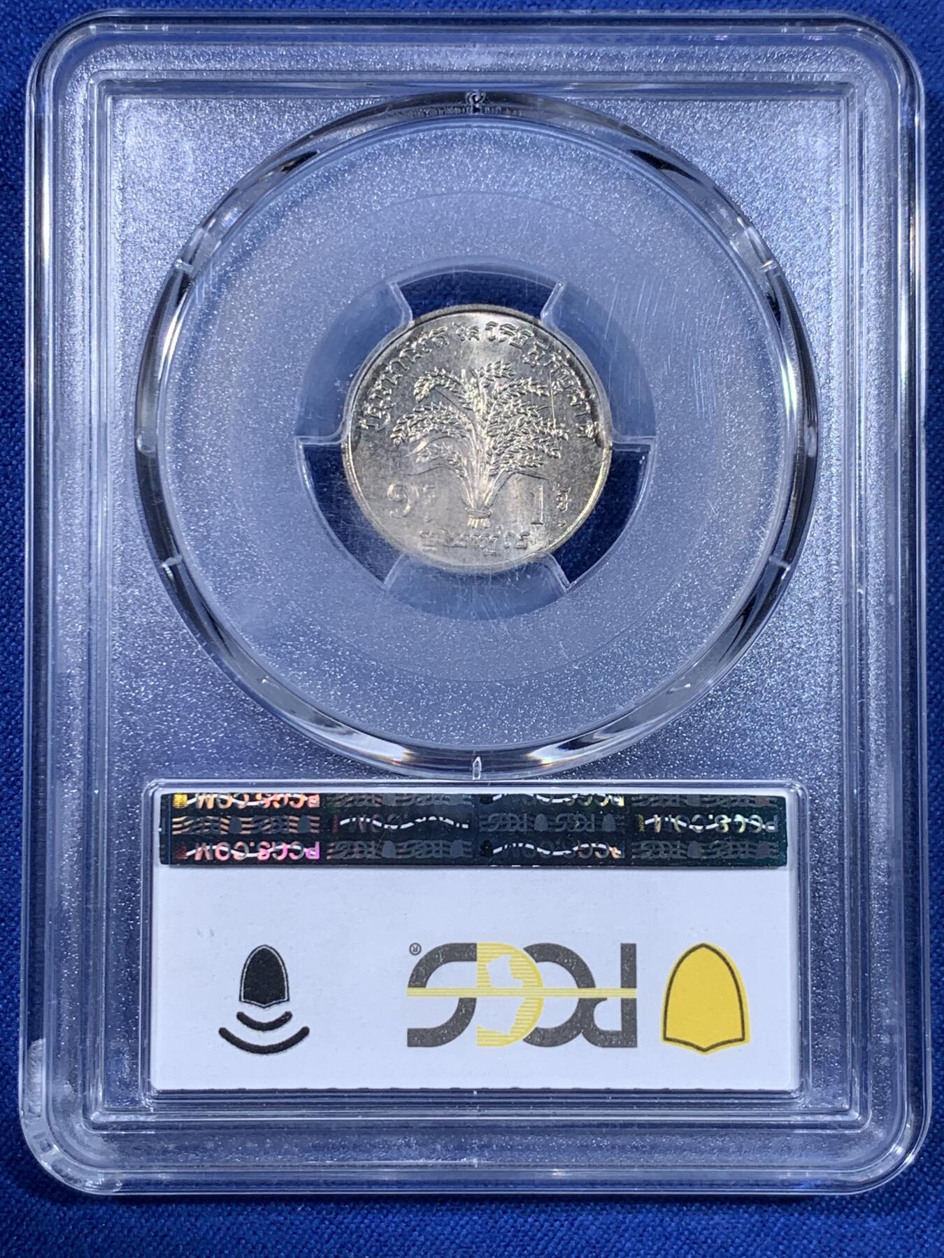 《竞宝斋》第439场 周日，周一，周二 3场连拍 （全场包邮） PCGS MS65 柬埔寨红色高棉政权发行的纪念币。英国皇家造币厂代工。1971年并没有发行。直到1980年代后市面上才陆续见到。数量稀少，盒子左上角有内裂纹。