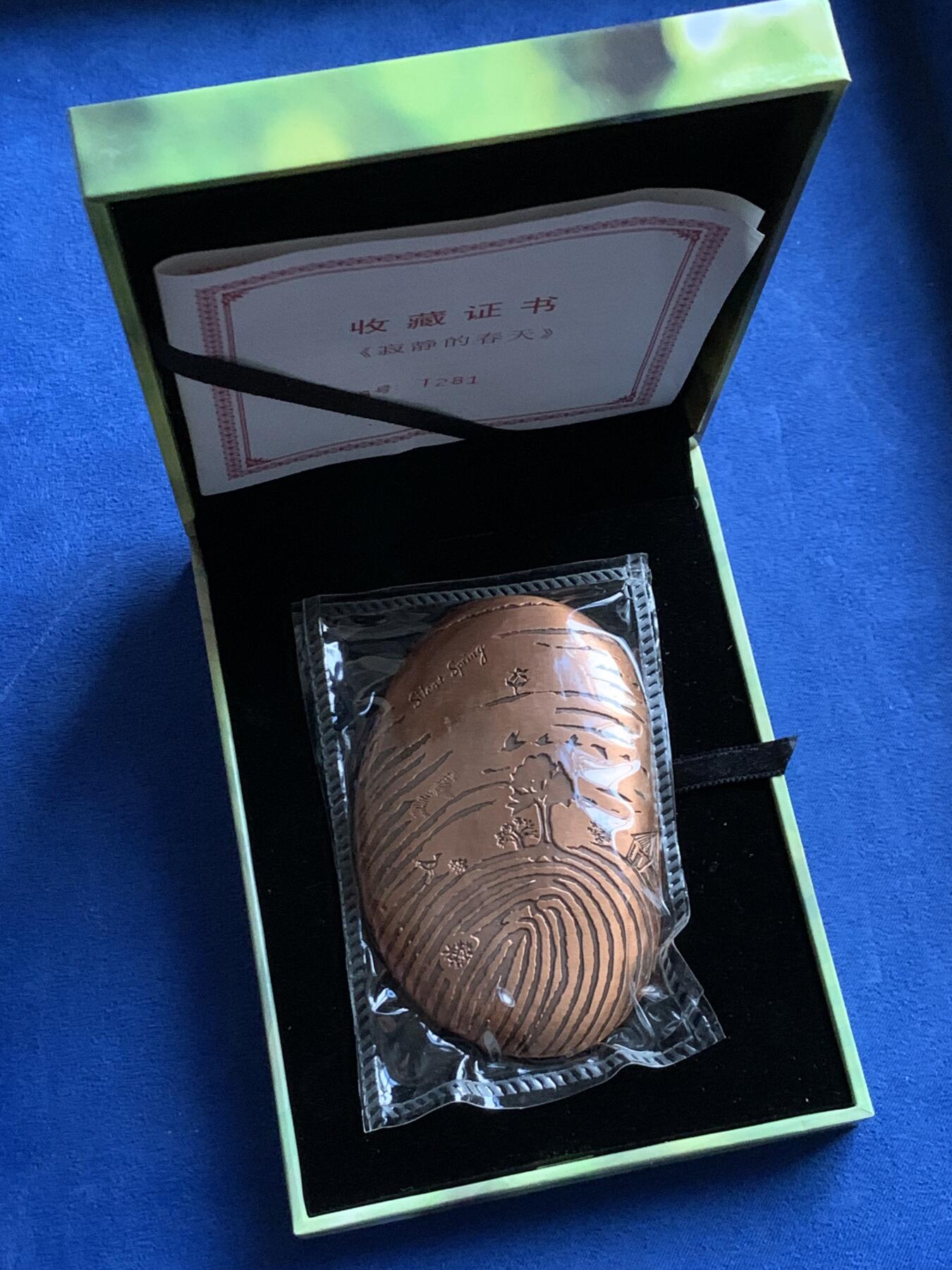 《竞宝斋》第439场 周日，周一，周二 3场连拍 （全场包邮） 寂静的春天铜章 采用新颖独特的鹅卵石形状 ，手感充实圆润 。人类细密的指纹 ，犹如岁岁年年的数轮，也如湖水荡漾的涟漪 。我们与大自然生生相惜 ，大自然就是我们的家 春意盎然 不再寂寞 不再静悄悄 ……规格为8.5cm×5.5cm，带袋总重约384.2克，限量发行黄铜365枚，紫铜365枚，发行编号水印证书 ，章上打号。