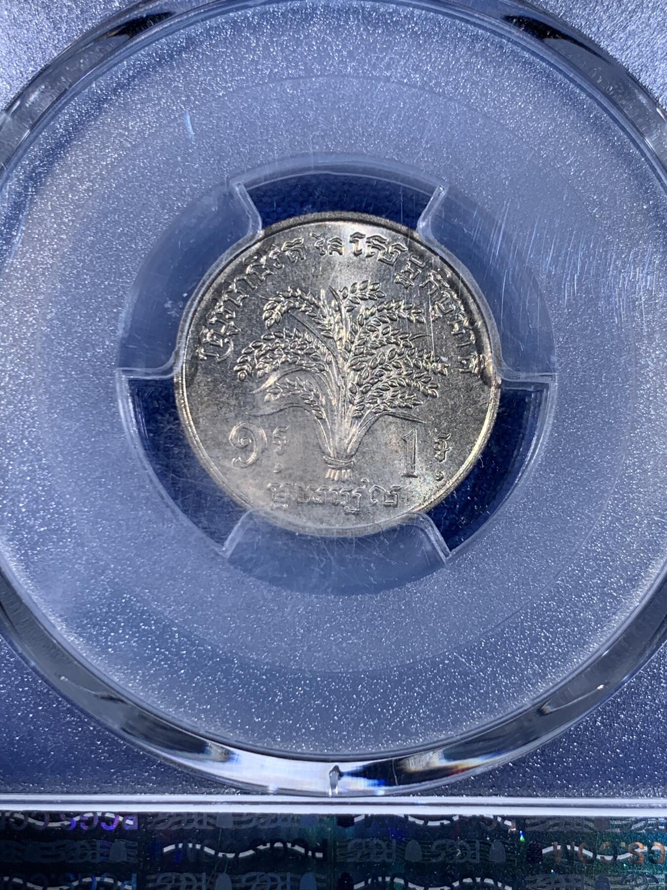 《竞宝斋》第439场 周日，周一，周二 3场连拍 （全场包邮） PCGS MS65 柬埔寨红色高棉政权发行的纪念币。英国皇家造币厂代工。1971年并没有发行。直到1980年代后市面上才陆续见到。数量稀少，盒子左上角有内裂纹。