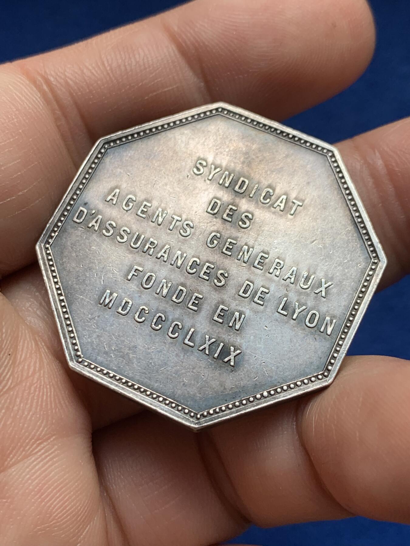 《竞宝斋》第440场 周日，周一，周二 3场连拍 （全场包邮） 1869年里昂综合保险银质八角代币，稀少品种，正面雄狮手持大宝剑图案，直径：36mm，重：21.6g