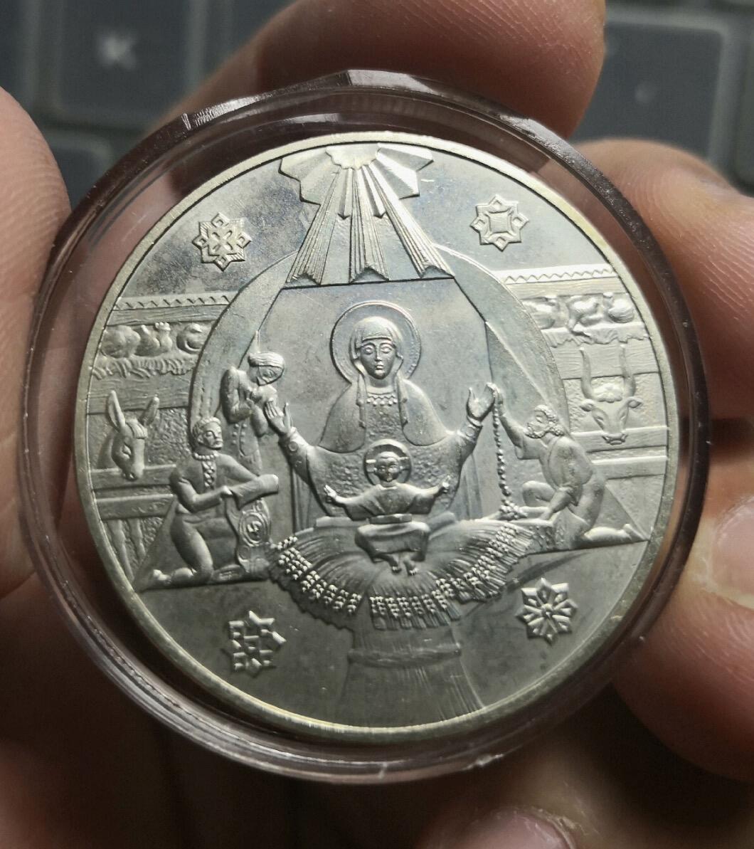  乌克兰传统节日Christmas eve纪念币，直径35mm，重16.54克。正面是面值5格里夫纳和加百列及乌列。反面是玛利亚，刚出生的Jesus和东方的三位智者。