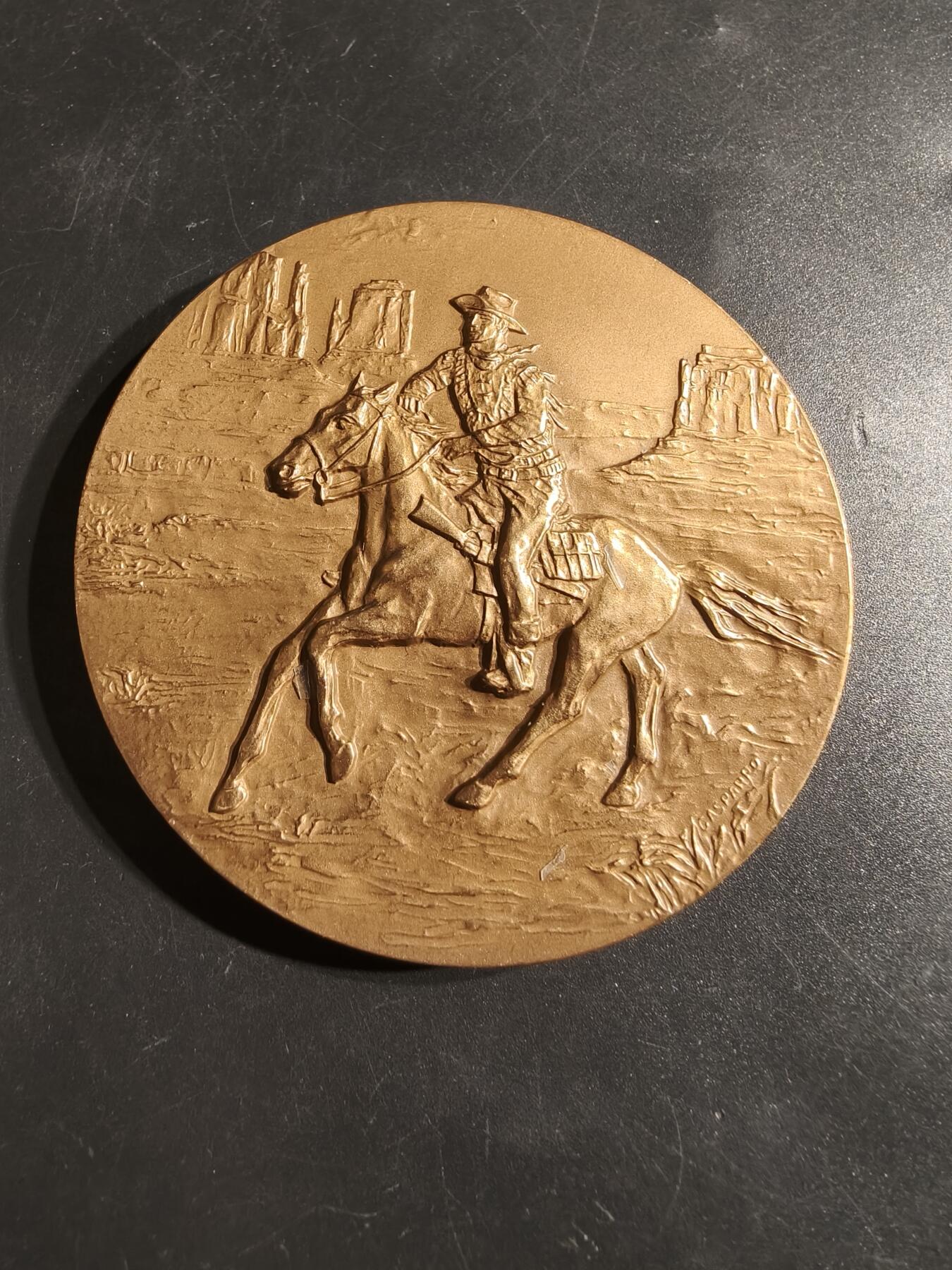 老王徽章第164期 美国铸币局著名西部片演员约翰•韦恩大铜章      原盒     直径76mm.    重量220.6g.      约翰·韦恩是一位标志性的美国演员，被视为美国精神的象征。  他曾被追授美国最高平民荣誉，包括国会金质奖章和总统自由勋章。 