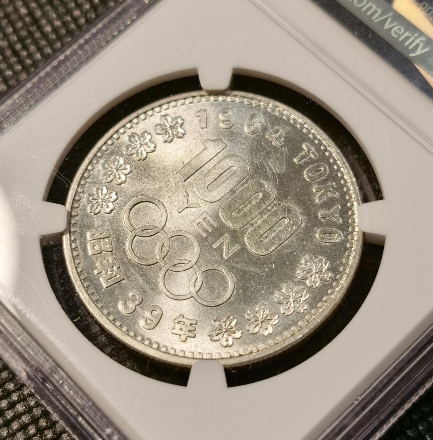 甄臻铺-世界币章拍卖（第40期）送拍享返佣金等优惠多多 NGC-MS63 日本1964年东京奥运1000元银币 车轮转光