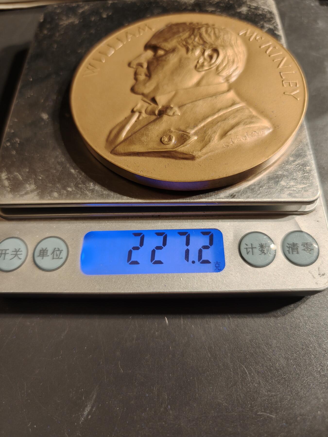 老王徽章第164期 美国铸币局威廉•麦金利总统大铜章     原盒带证书     直径76mm.   重量227.2g.    威廉·麦金利是美国第25任总统，任期从1897年3月4日开始，直至1901年9月14日遇刺身亡。他是最后一位曾参加南北战争的美国总统。  纪念章通常用于纪念特定人物或事件，其价值取决于稀有性、历史背景和保存状况。背面描绘了一个女性形象，可能象征着哀悼或自由   