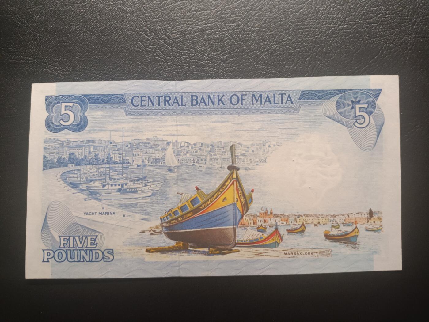 2025十一月第五期，总第203期 马耳他1974版5里拉UNC-有针孔，国徽和彩绘马萨洛克港，上方缺口是安全线收紧的自然工艺，介意者勿拍