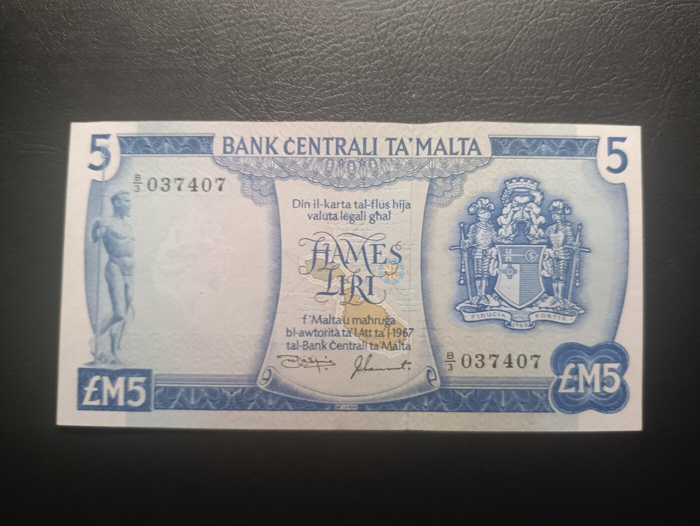 2025十一月第五期，总第203期 马耳他1974版5里拉UNC-有针孔，国徽和彩绘马萨洛克港，上方缺口是安全线收紧的自然工艺，介意者勿拍