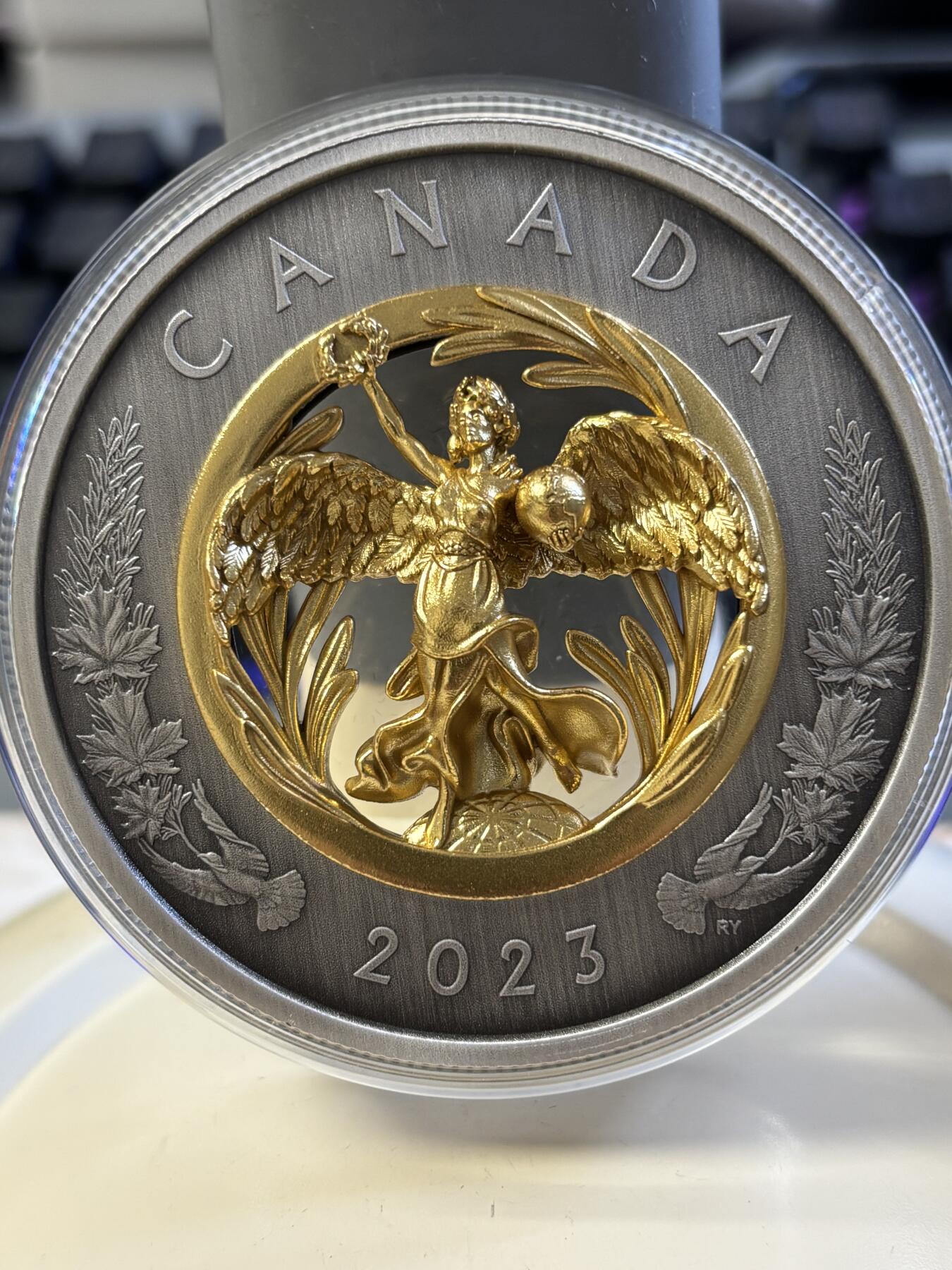 第182期拍卖 获奖加拿大2023年镂空镶嵌胜利与和平女神镀金纪念银币，9999银镀金，2盎司，发行1250枚。获克劳斯2024年度最富激情币大奖