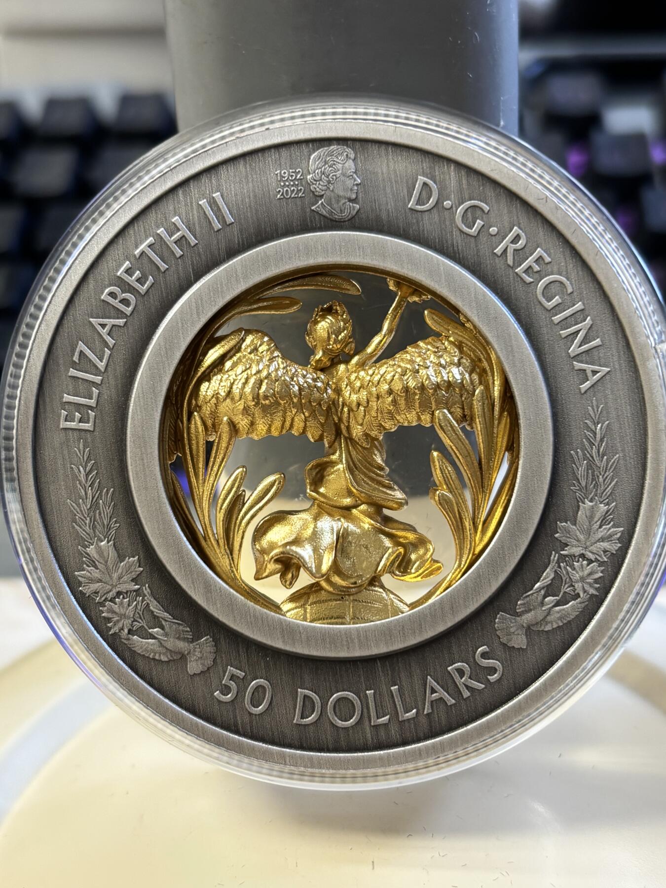 第182期拍卖 获奖加拿大2023年镂空镶嵌胜利与和平女神镀金纪念银币，9999银镀金，2盎司，发行1250枚。获克劳斯2024年度最富激情币大奖