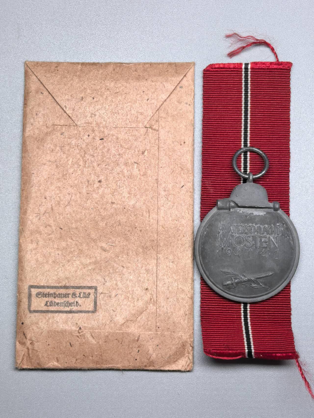 小驴勋章奖章收藏11月22日周六晚六点拍卖（珍爱和平，收藏战争，铭记历史，勿忘国耻，忠党爱国。有偿代拍，送拍规则在简介最后，参拍须阅读规则后再参拍，关系到运费包装发货时效真假辨别等关键信息，拍卖时不再发原图，看大图店主微信码在拍卖店铺介绍里） WWII东线冬季作战奖章带原纸袋，环打4厂标，锌合金镀银，纸袋背印Steinhauer & Lück Lüdenscheid厂标，镀层自然氧化没有佩戴痕迹划痕