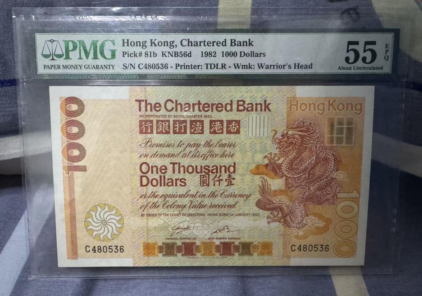 《外钞收藏家》第五百八十七期（精选场）（本平台长期征集拍品、欢迎藏友们联系合作） 【带e大金龙】香港渣打1982年大金龙1000元 超稀有C冠号 PMG 55 epq 带e非常难得 配套不可或缺 65分的都要十万+了，55e的拍卖行情2万+ 香港本土都是天价 Hong Kong, Chartered Bank, 1000 Dollars KNB56d    1982
