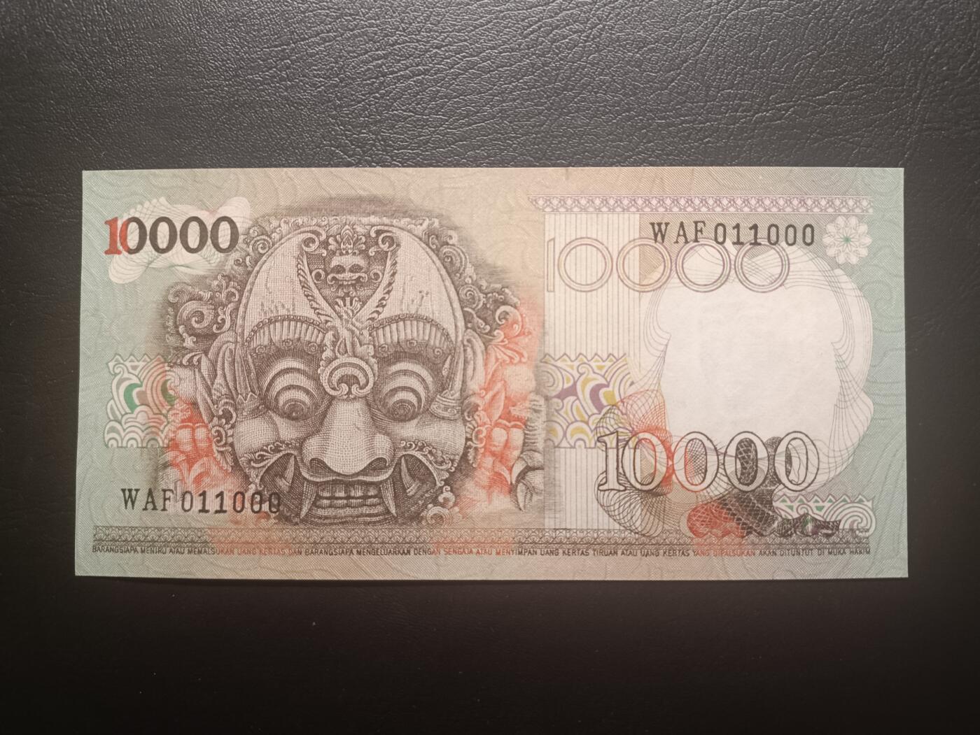 2025十一月第六期，总第204期 印度尼西亚1975版10000卢比AUNC，稀有无47二进制倒置豹子号011000，佛塔浮雕和传统工艺面具，此版本最大面值