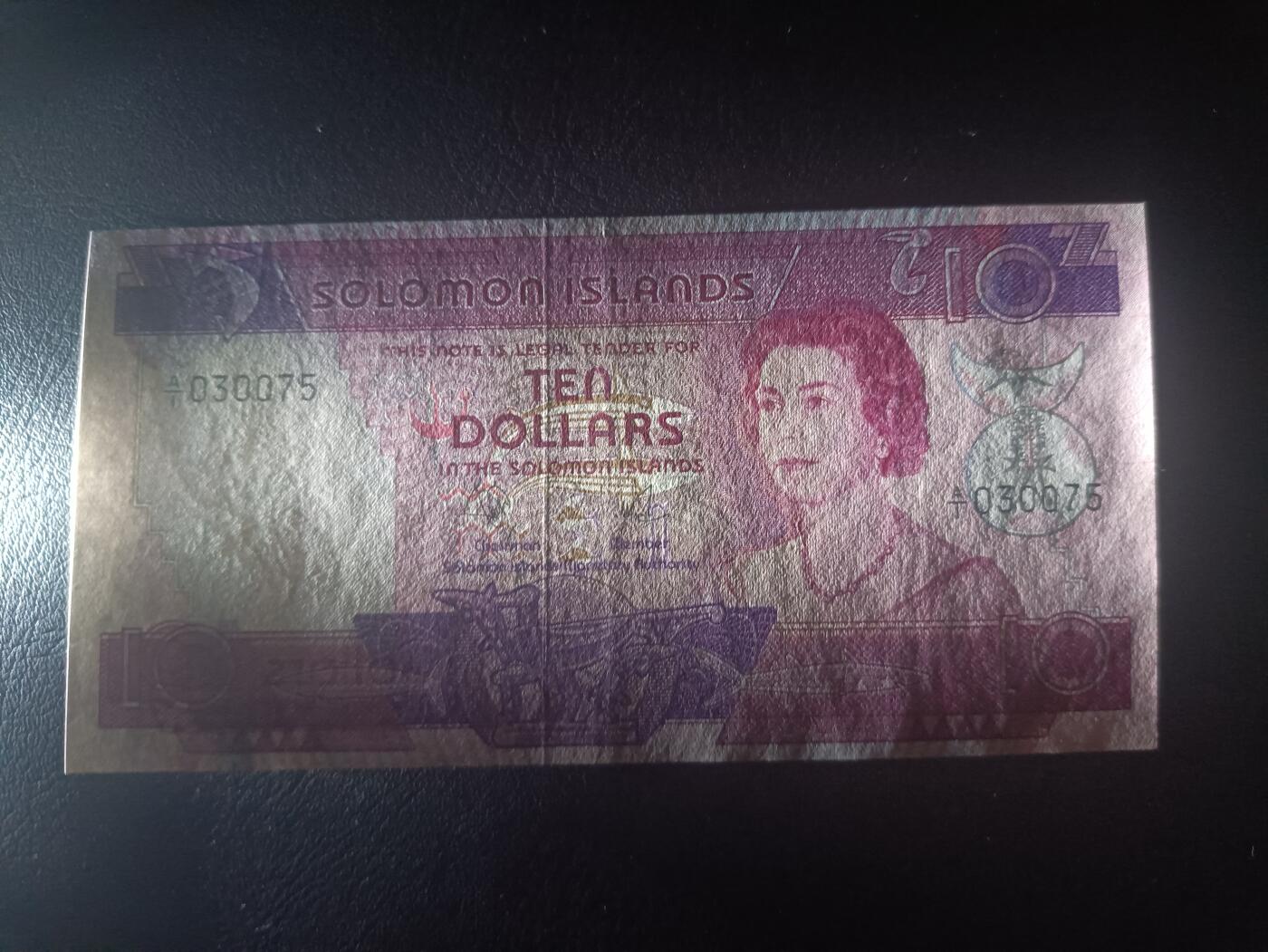 2025十一月第六期，总第204期 所罗门群岛1977版10元AUNC有裂口首冠A/1，中年女王和传统手工业