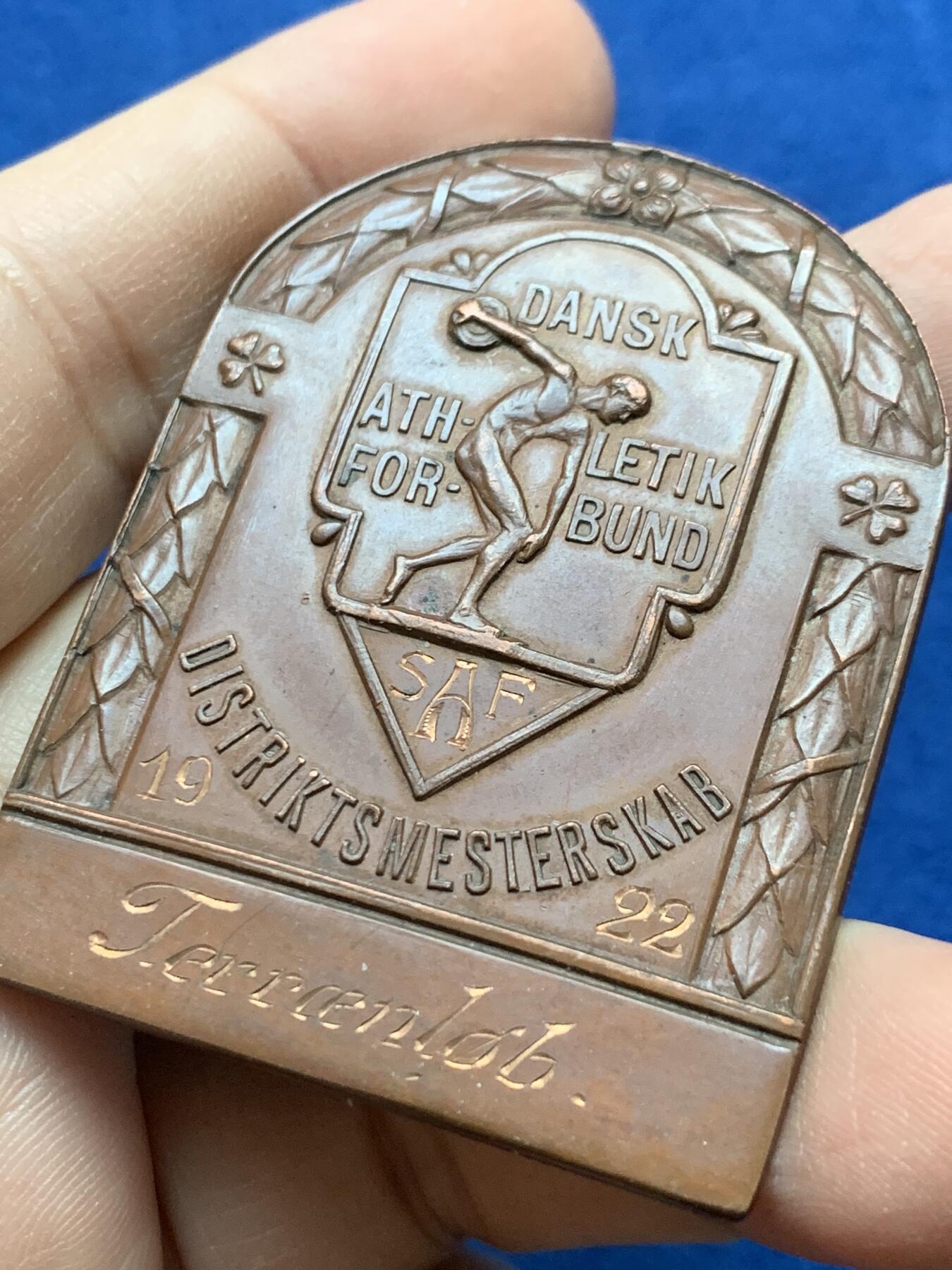 《竞宝斋》第442场 周日，周一，2场连拍 （全场包邮） 丹麦王国1922年国家田径越野竞赛异形铜章，实名刻发，背带厂标， 尺寸54.8m m×41.7mm，重量40.95g，百年巧克力包浆美品。