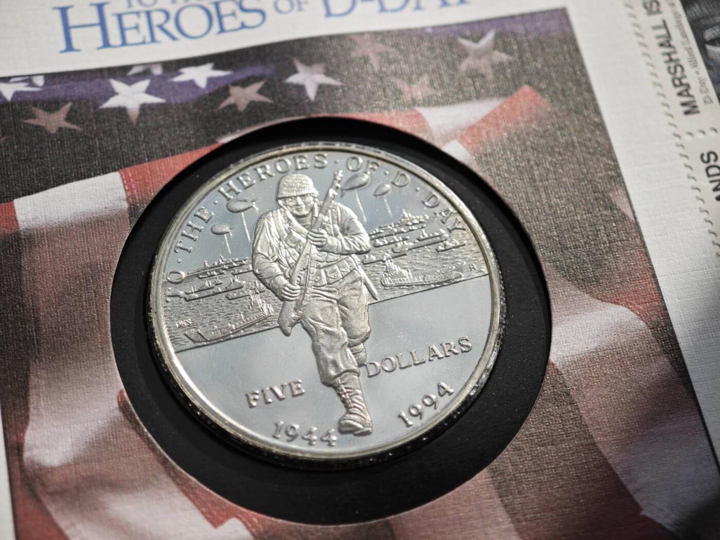 盛世勋华——号角文化勋章邮票专场拍卖第289期 美属马绍尔群岛1994年诺曼底登陆50周年5元纪念币邮币封，限量发行，包含一枚5美元纪念币与一套4枚75分纪念邮票。4枚邮票图案分别展示了D-Day相关元素（战机、岸防炮、登陆舰队等），均标注“D-Day June 6th Normandy 1944”。