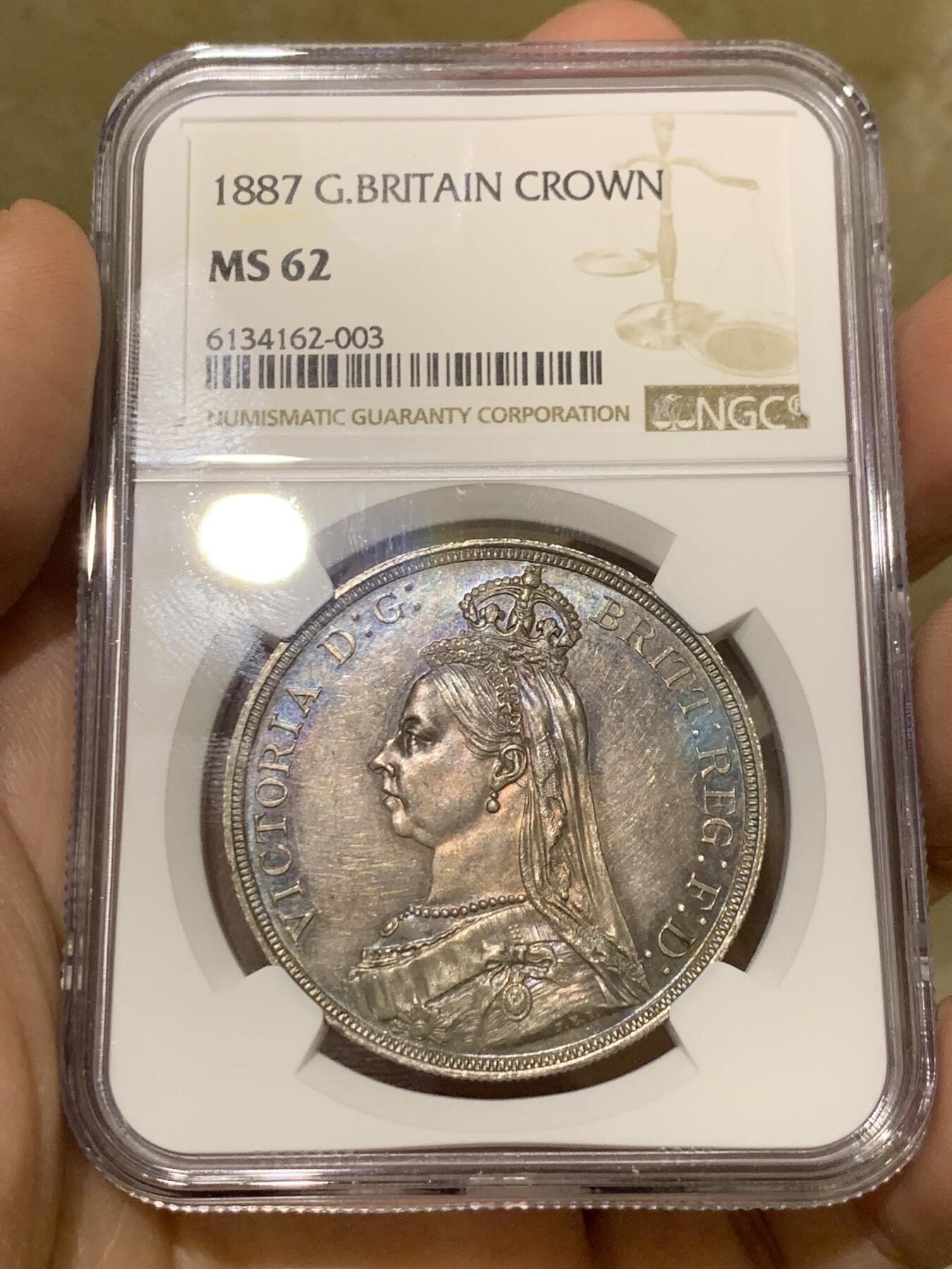 《竞宝斋》第442场 周日，周一，2场连拍 （全场包邮） NGC MS62 英国1887年高冠马剑1克朗银币 双面深五彩包浆，整体状态优秀。