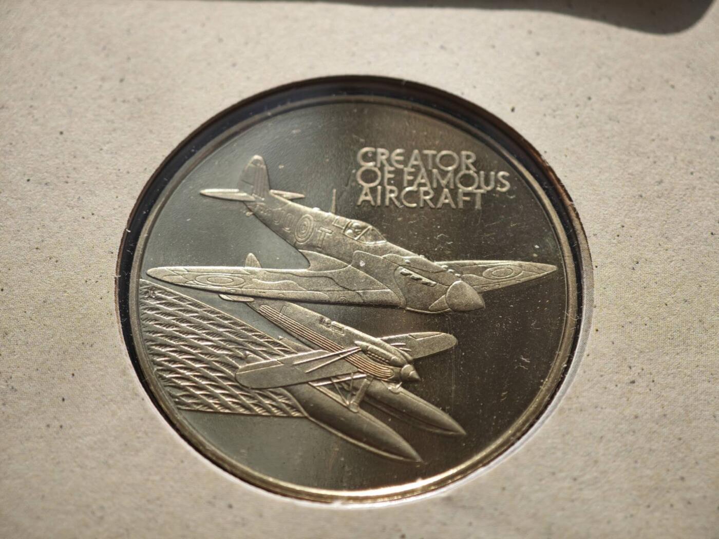 盛世勋华——号角文化勋章邮票专场拍卖第289期 英国1995年“米切尔（喷火战斗机总设计师）诞辰百年”纪念币封，币面为米切尔头像，由英国皇家铸币厂（Royal Mint）铸造； 邮票包含英国女王头像的1便士邮票，及一枚印有米切尔肖像与喷火式战斗机设计图的纪念邮票，编号NO 29980，限量发行，米切尔是英国航空工程师，核心作品为喷火式战斗机，该机型以椭圆机翼+梅林发动机实现高机动性，是二战不列颠空战的核心战机，是航空史经典设计之一。