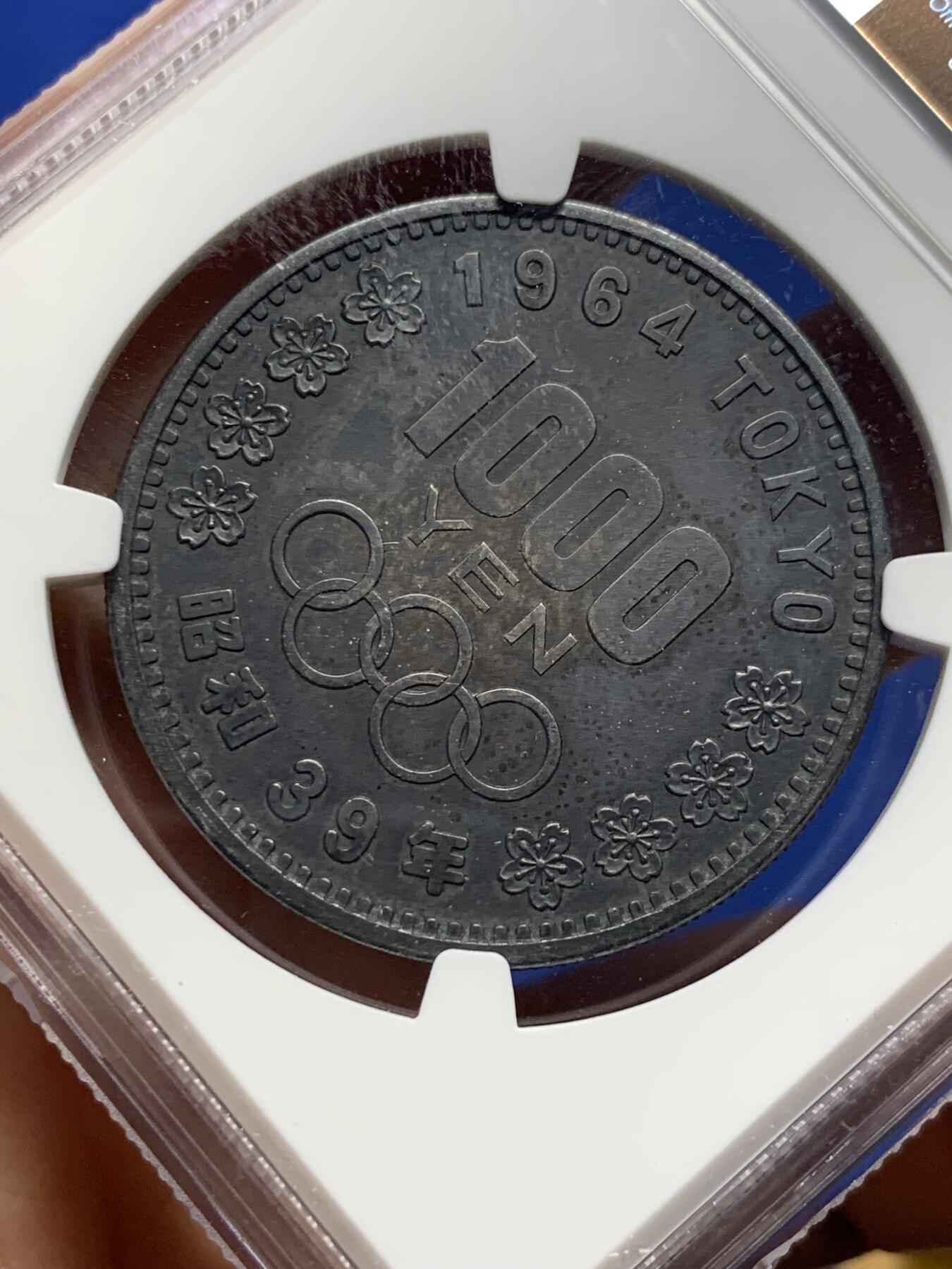 《竞宝斋》第442场 周日，周一，2场连拍 （全场包邮） NGC MS61 日本1964年1000日元奥运会纪念币，双面黑漆古老包浆，导致分数偏低，但高点都在，底板平整，很漂亮的一枚