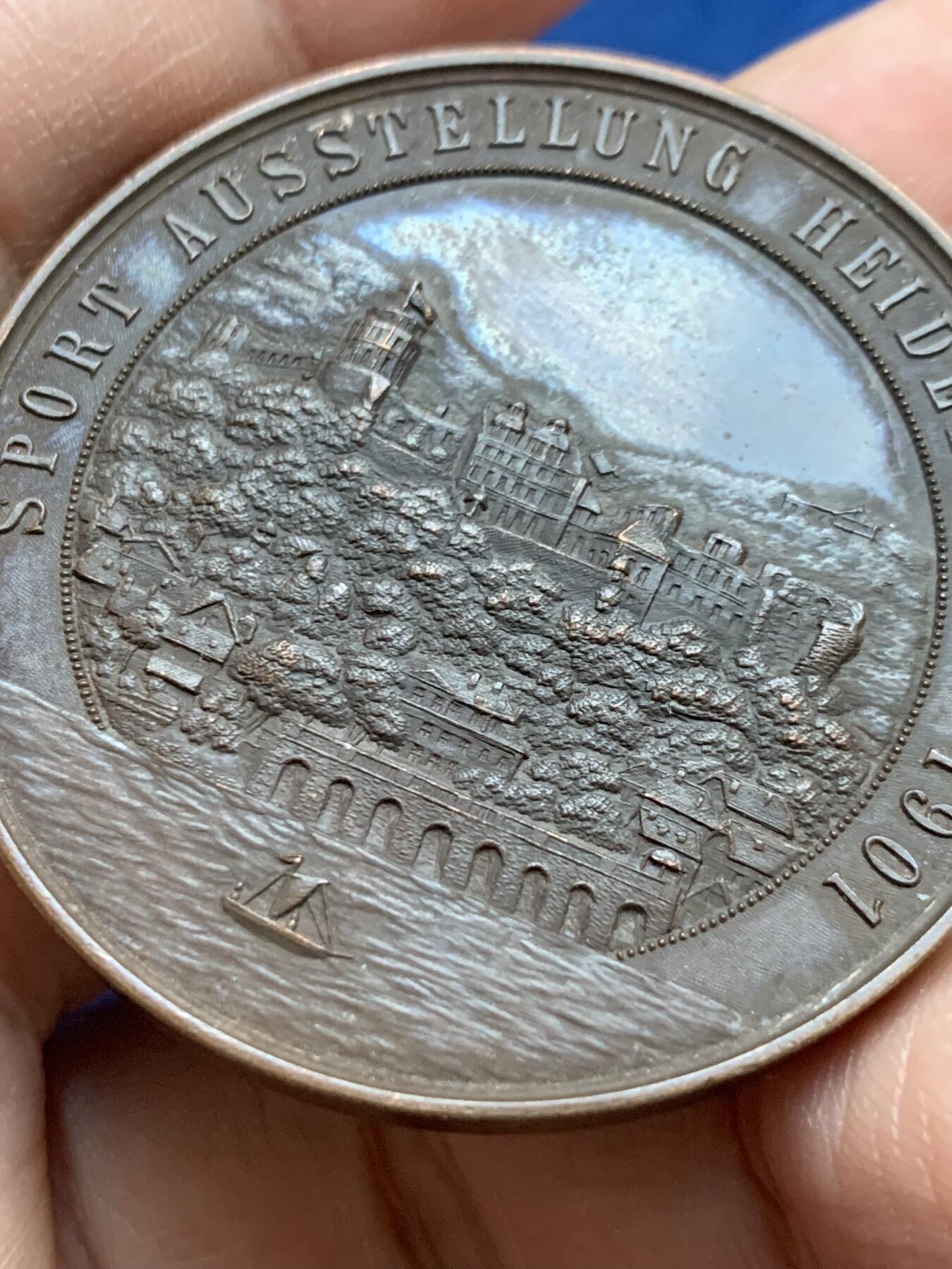 《竞宝斋》第442场 周日，周一，2场连拍 （全场包邮） 德国第二帝国1901年景观奖章-体育奥斯塔隆海德堡，材质青铜，直径45MM，重40.5g 。这枚奖章是在1901在德意志帝国(第二帝国)为了纪念ausstellung(体育展览)持有时间海德堡。当时，德国正经历着快速的工业化，人们对有组织的体育、体育和公共展览的兴趣日益浓厚。这项活动可能展示了田径、体操和其他体育学科的进步，反映了威廉明时代国家对健康和健身的重视。