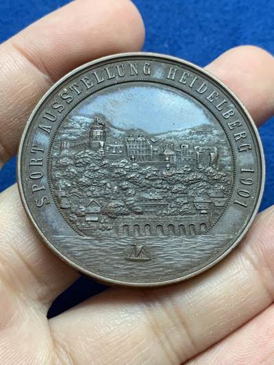 《竞宝斋》第442场 周日，周一，2场连拍 （全场包邮） - 德国第二帝国1901年景观奖章-体育奥斯塔隆海德堡，材质青铜，直径45MM，重40.5g 。这枚奖章是在1901在德意志帝国(第二帝国)为了纪念ausstellung(体育展览)持有时间海德堡。当时，德国正经历着快速的工业化，人们对有组织的体育、体育和公共展览的兴趣日益浓厚。这项活动可能展示了田径、体操和其他体育学科的进步，反映了威廉明时代国家对健康和健身的重视。