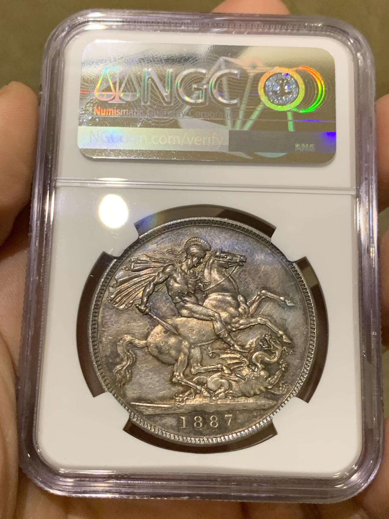 《竞宝斋》第442场 周日，周一，2场连拍 （全场包邮） NGC MS62 英国1887年高冠马剑1克朗银币 双面深五彩包浆，整体状态优秀。