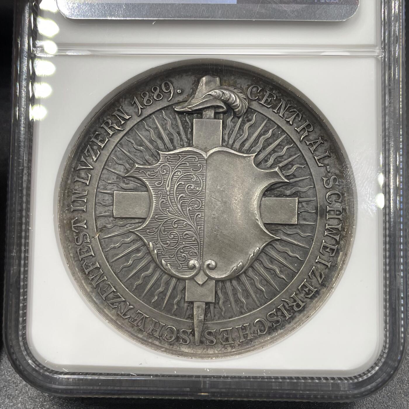 「木头集藏」章牌精品专场！ Bovy~1889年瑞士卢塞恩射击节银章， MS61 ，直径:45mm，NGC加厚盒，分数略低评。高浮雕非常精美，整个人物呼之欲出，特别是人物头部的雕刻，已经不是平面的浮雕了，而几乎是立体的圆雕，可以说是体现瑞士射击节章牌高超艺术水准和铸造工艺的代表作品。