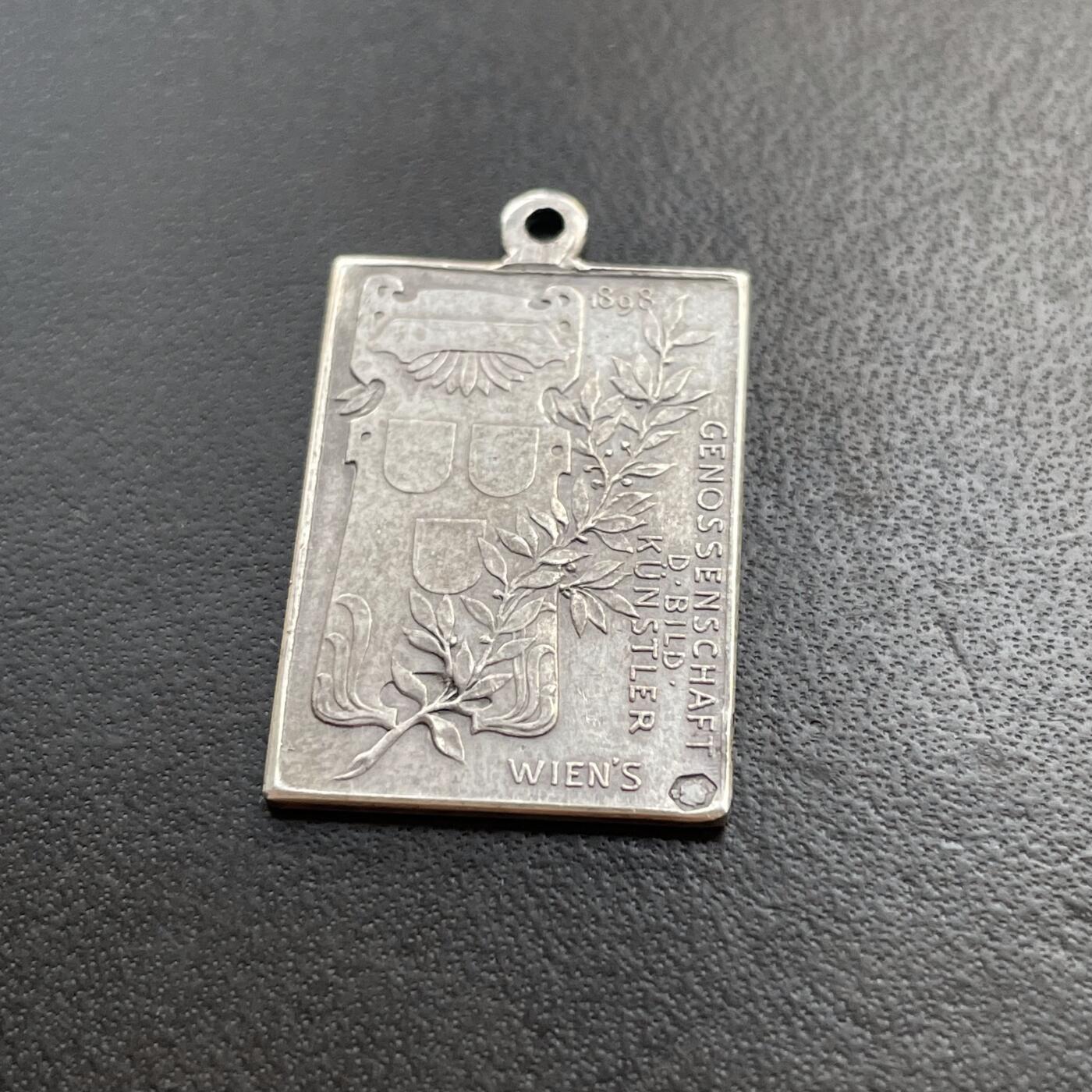 「木头集藏」章牌精品专场！    Anton Scharff～1898年奥地利弗朗茨皇帝在位50周年纪念银章 ，尺寸：23×16mm，3.6g，雕刻大师安东·沙夫非常罕见的一款作品。尺幅虽小但是银标和厂铭打得都很清晰。此章是奥地利美术家协会为纪念弗朗茨皇帝在位50周年而特别委托铸造。