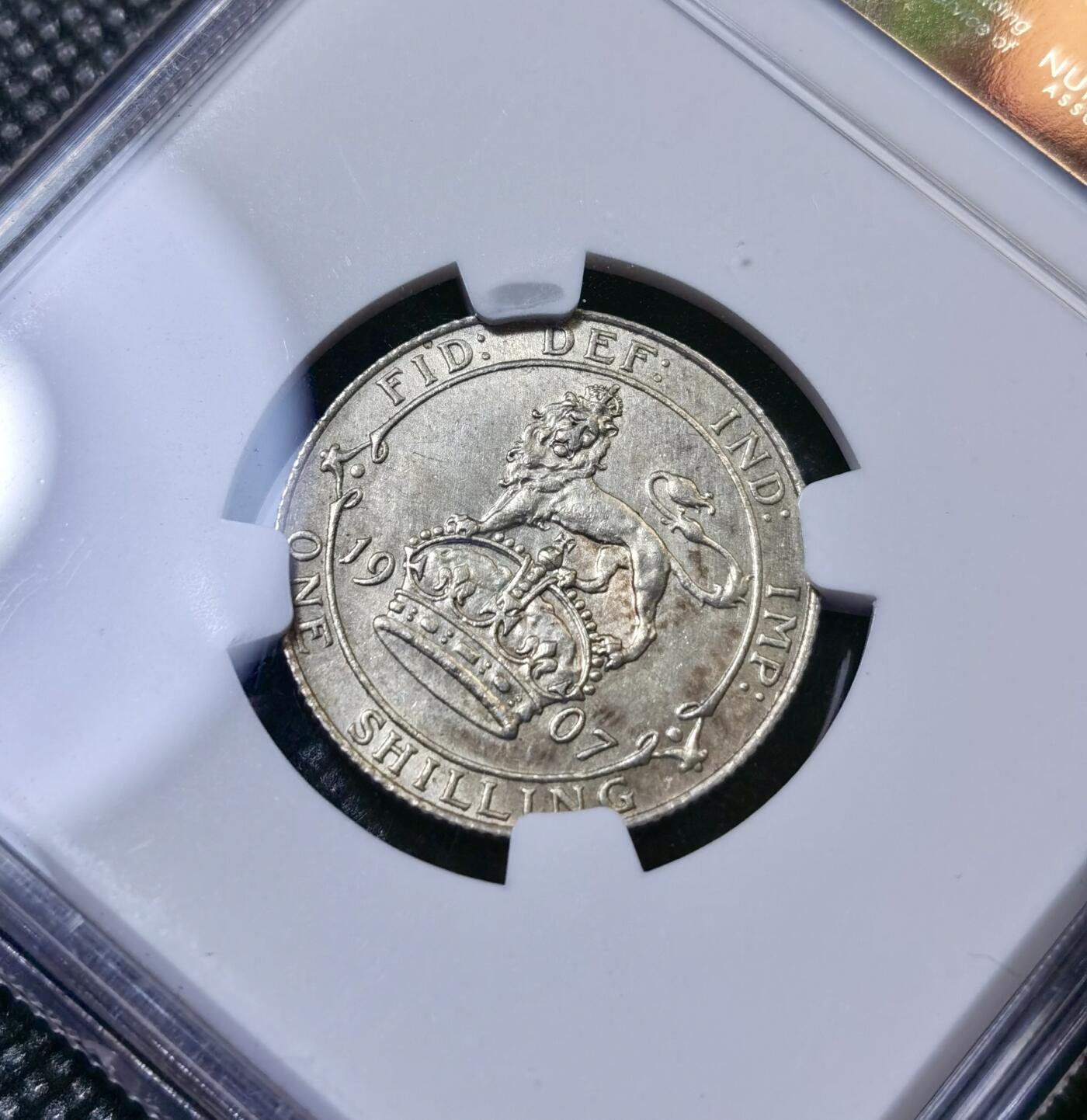 甄臻铺-世界币章拍卖（第40期）送拍享返佣金等优惠多多 NGC-UNCD 英国1907年爱德华七世站狮1先令银币 错杀状态 63分的转光