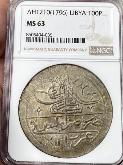 万国钱币拍卖第056期 - NGC MS63 利比亚1796年（AH1210）年100帕拉大银币，以奥斯曼土耳其塞利姆三世的名义发行，在的黎波里铸造。实际此时的利比亚在本土贵族卡拉曼尼家族的统治下高度自治。与土耳其和其他阿拉伯大部分地区的钱币不同，利比亚地区只铸造了5个年份且数量极其稀少，此枚为最后的年份。N和P双料冠军，唯一的MS记录。类似品种的利比亚VF在HA成交价1440美金。