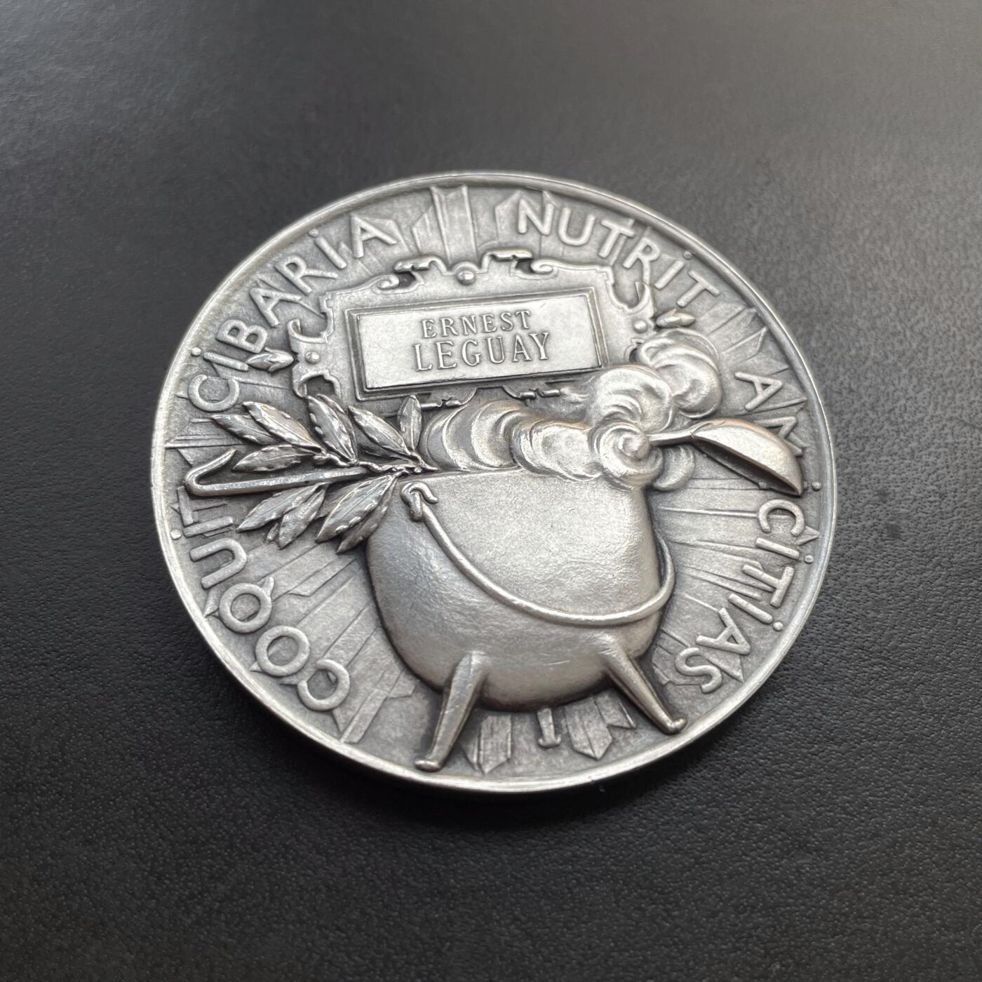 「木头集藏」章牌精品专场！ O Roty～法国烹饪协会宴会纪念镀银铜章 ，直径：51mm，边铭：丰饶角 BRONZE，正面的这款玛丽安娜肖像是罗蒂较早期的作品。章上的年份1873是烹饪协会成立的时间，并不是罗蒂创作这枚章的时间。罗蒂创作的时间大约在1880年代。  法国烹饪协会实际上是一个社交俱乐部，通过定期举办宴会，以表彰艺术、科学和政治领域的杰出人士，因此这个宴会就成为了一个名流云集的重要场合。