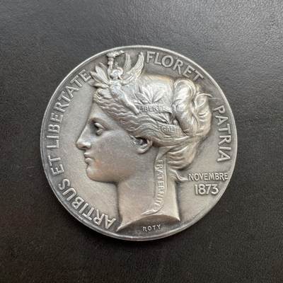 「木头集藏」章牌精品专场！ - O Roty～法国烹饪协会宴会纪念镀银铜章 ，直径：51mm，边铭：丰饶角 BRONZE，正面的这款玛丽安娜肖像是罗蒂较早期的作品。章上的年份1873是烹饪协会成立的时间，并不是罗蒂创作这枚章的时间。罗蒂创作的时间大约在1880年代。  法国烹饪协会实际上是一个社交俱乐部，通过定期举办宴会，以表彰艺术、科学和政治领域的杰出人士，因此这个宴会就成为了一个名流云集的重要场合。