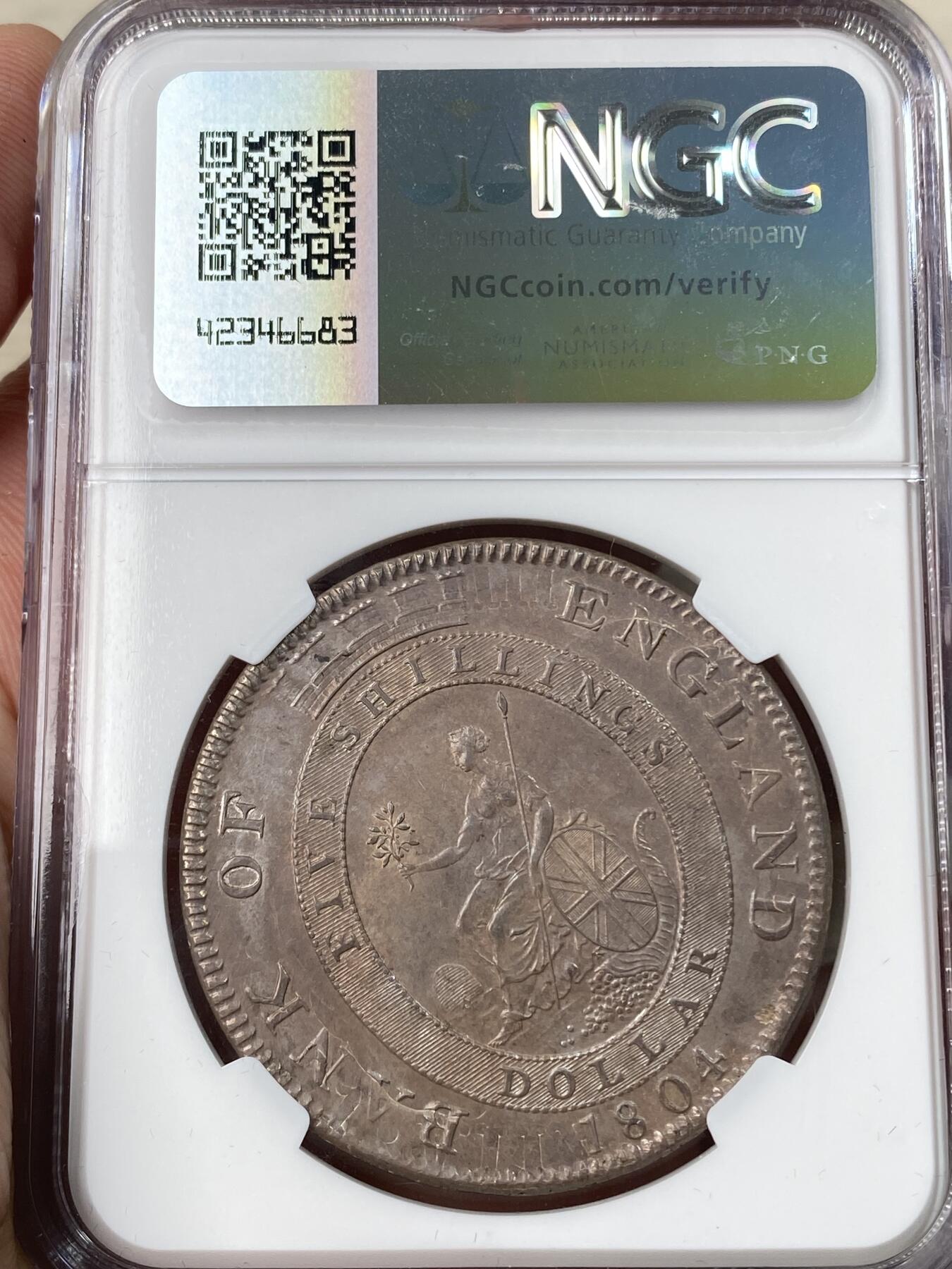 万国钱币拍卖第056期 NGC AU58 1804年英国乔治三世英格兰银行5先令大银币 英国白银短缺时期的产物 直接压印在西班牙双柱之上 双柱影子依稀可见 原味纸袋包浆非常诱人