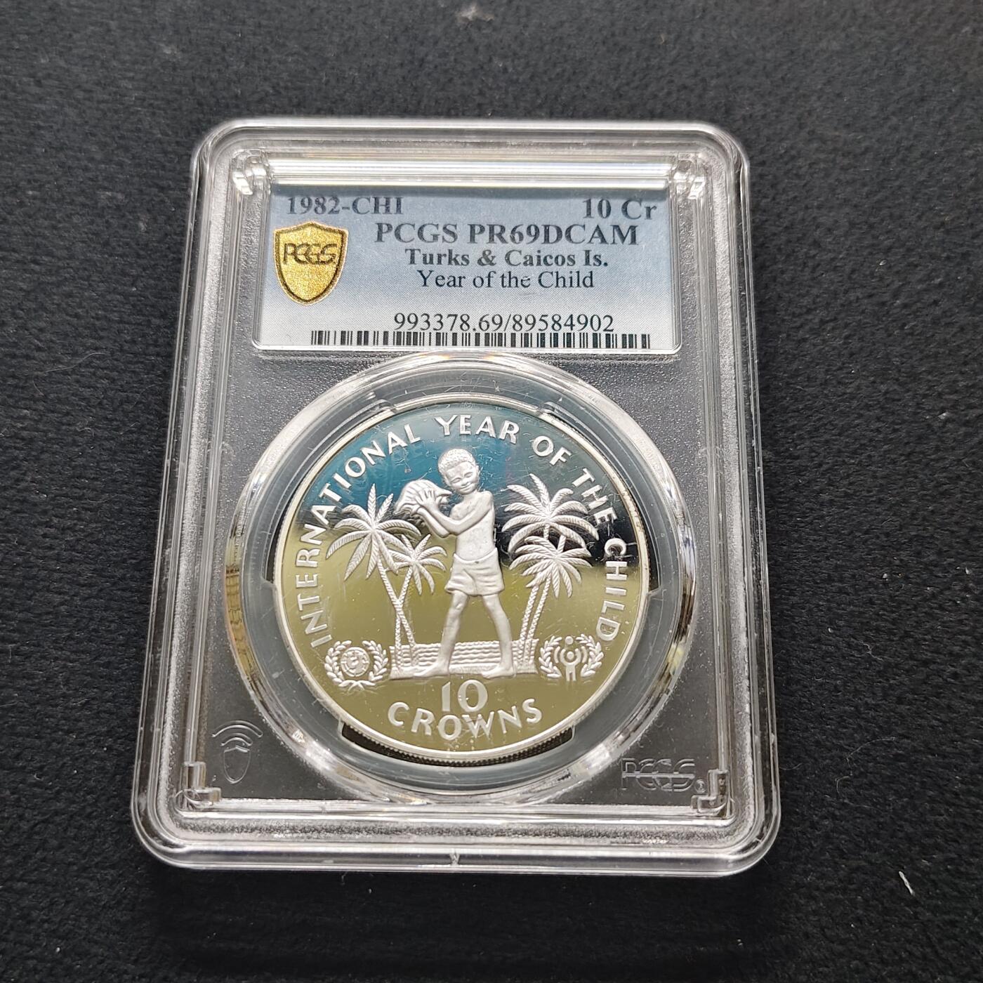 【全场包邮】纯粹捡漏拍481场（免费代拍第18场） 【少见】特克斯和凯克斯群岛1982年10克朗国际儿童年精制纪念银币-量7928-PCGS PR69 DCAM