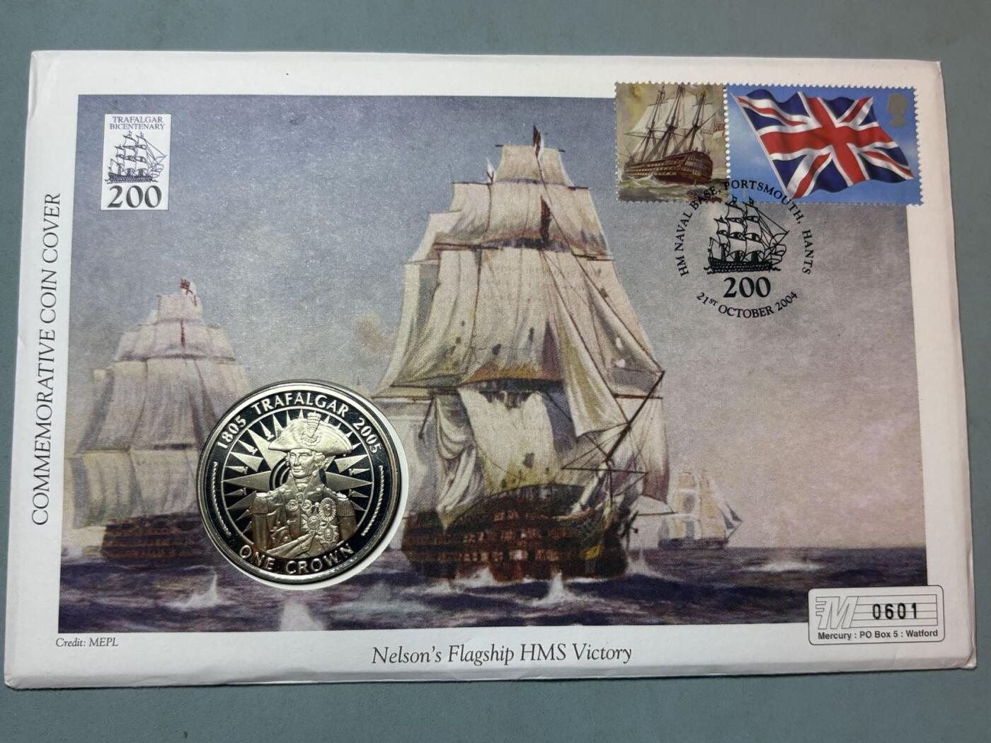 盛世勋华——号角文化勋章邮票专场拍卖第291期 英国马恩岛2005年特拉法尔加海战200周年纪念币首日收藏封，含邮票、插画、克朗型纪念币封装，限量发行，编号0601，纪念1805年英国海军在特拉法尔加海战中击败法西联合舰队的战役，主角是英国海军名将纳尔逊的旗舰“胜利号（HMS Victory）”，2005年是该战役200周年纪念节点。